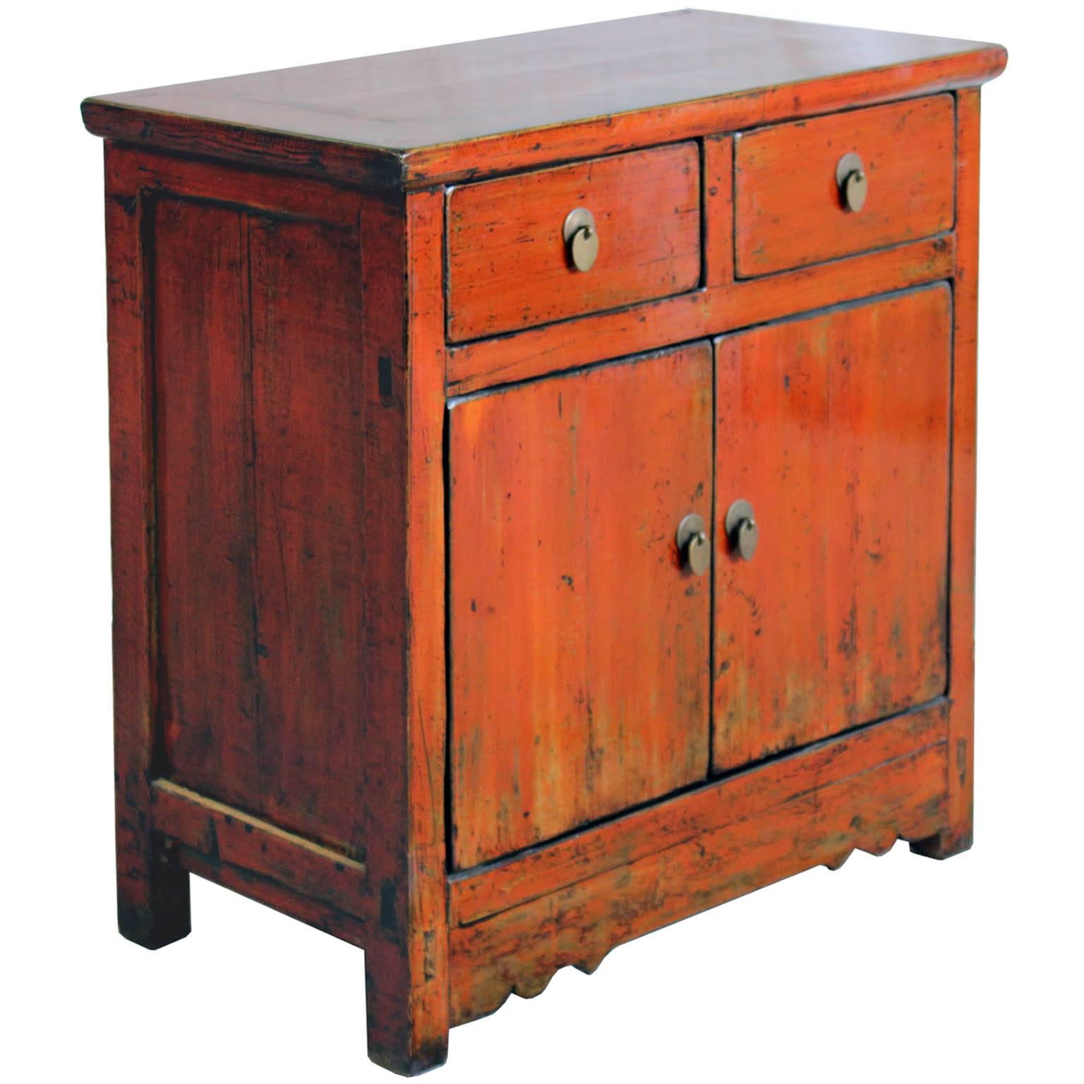 Two-drawer orange side chest with exposed wood edges and carved bottom skirt . New interior shelf and hardware. Gansu, China, circa 1890s. 