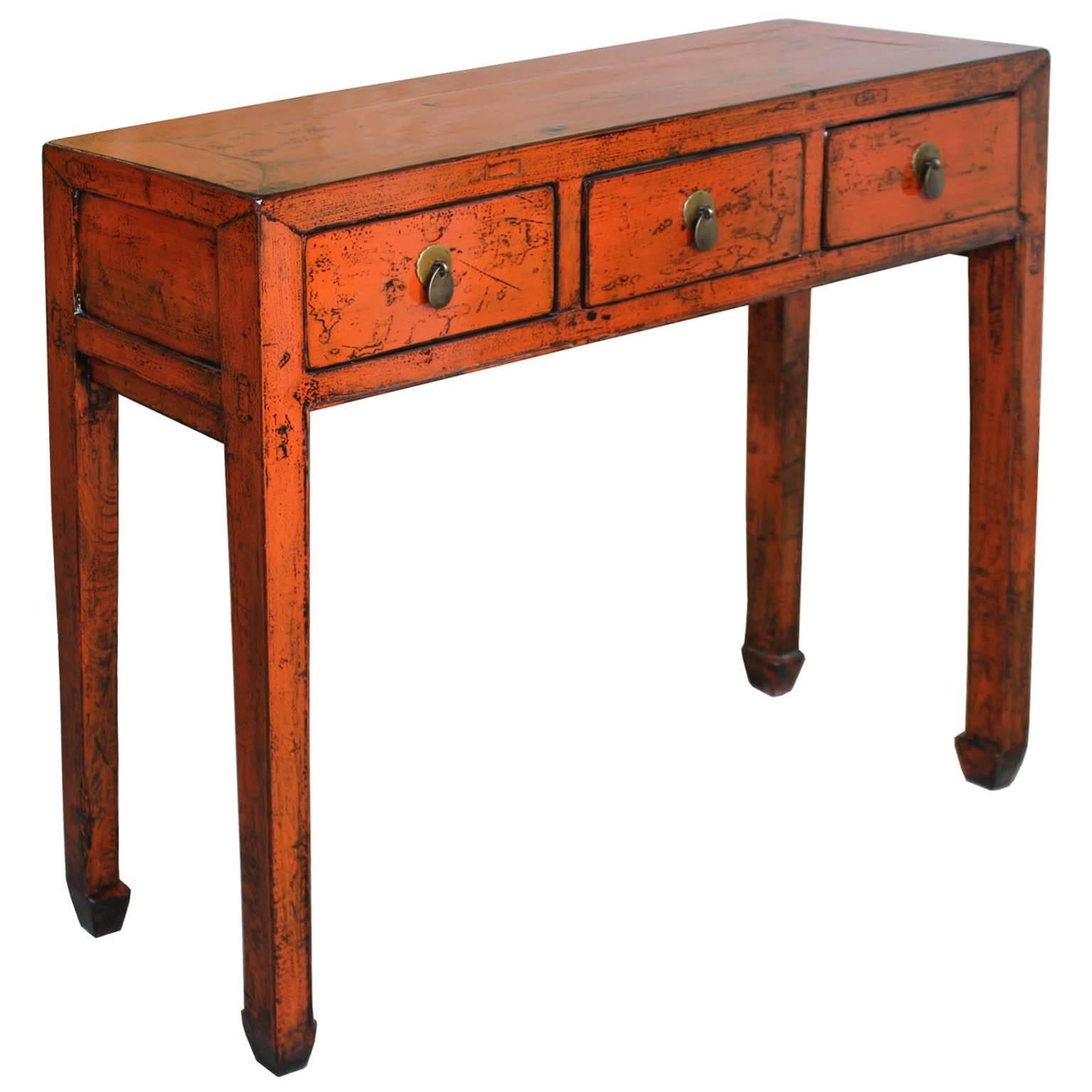 Three-drawer orange lacquer console table with horse-hoof feet, Shandong, China, circa 1900. New hardware. Some wear.
              