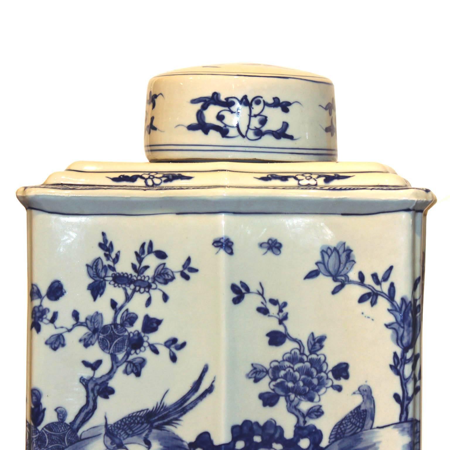 Elegant blue and white tea containers with hand-painted birds perched on cherry branches can be displayed on a bookshelf or console table. Available individually at $525 each.
