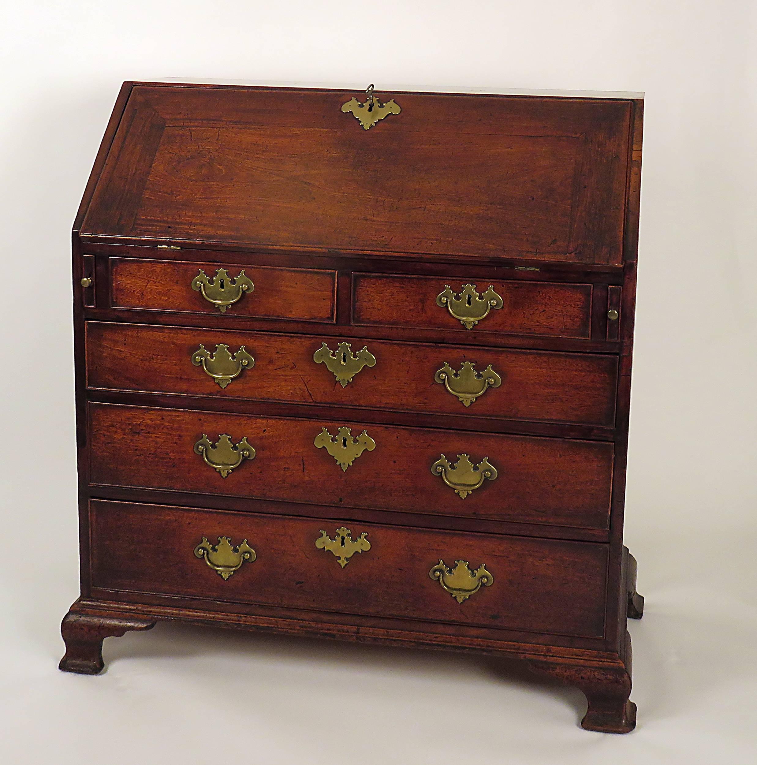 18th century English mahogany slant front desk in remarkable good condition. Rare smaller scale. Old, possibly original finish. Well fitted interior with secret compartments. Standing on four ogee bracket original feet.
