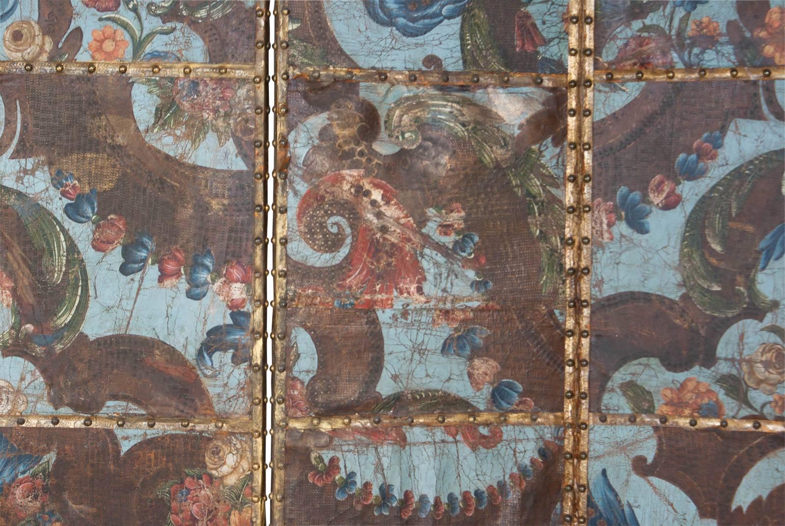 A decorative Spanish tooled leather screen decorated with gilding and paint. The tooled leather is from the 1700s when it was used for covering walls in important homes. The screen frames are often later and where used to re-purpose and conserve