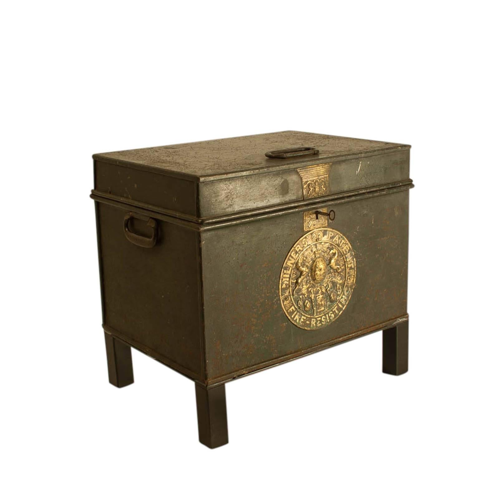 English bottle green painted metal fire safe with gilt brass escutcheons, key and Royal Warrant, circa 1860. Standing on custom iron stands. The interior painted bright green with printed instructions. We have another similar example.