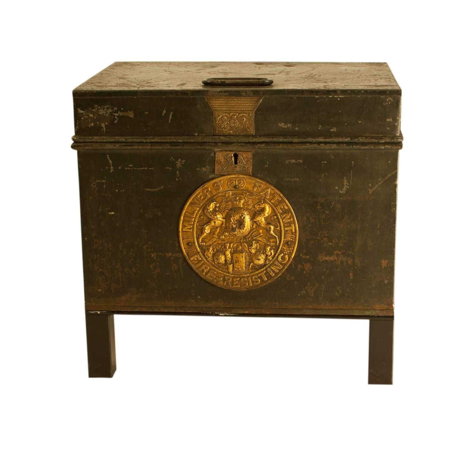 English Bottle Green painted metal fire safe with gilt brass  escutcheons and Royal Warrant, circa 1860.  Standing on custom iron stands.  The interior painted bright green with printed instructions.  We have another similar example.  