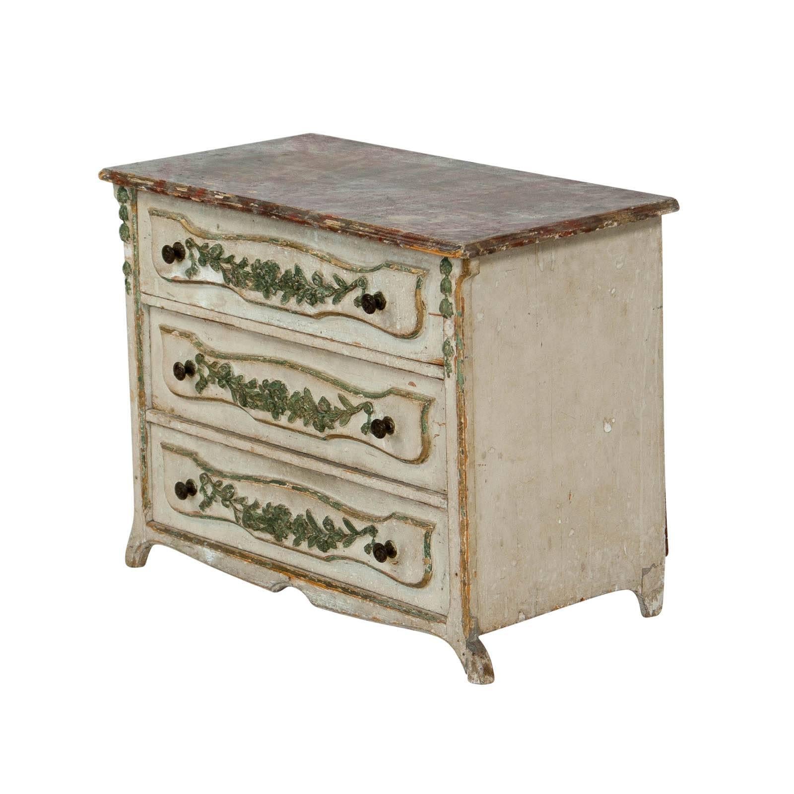An Italian painted miniature chest or commode in the 18th century style of a piece made in the North near Piedmont. Great rare decorative piece from a very good collection. Nice old painted surface with well carved details. Possibly earlier.