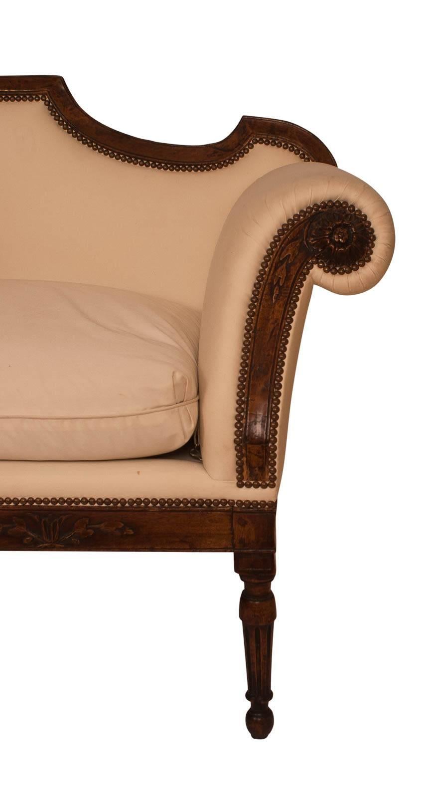 A beautiful neoclassical walnut Italian sofa or settee circa 1810.  Wonderful carved details.  The rosettes and garlands that decorate the front of the piece are very beautiful.  The shaped rail is very nice as are the legs.  The upholstery is in