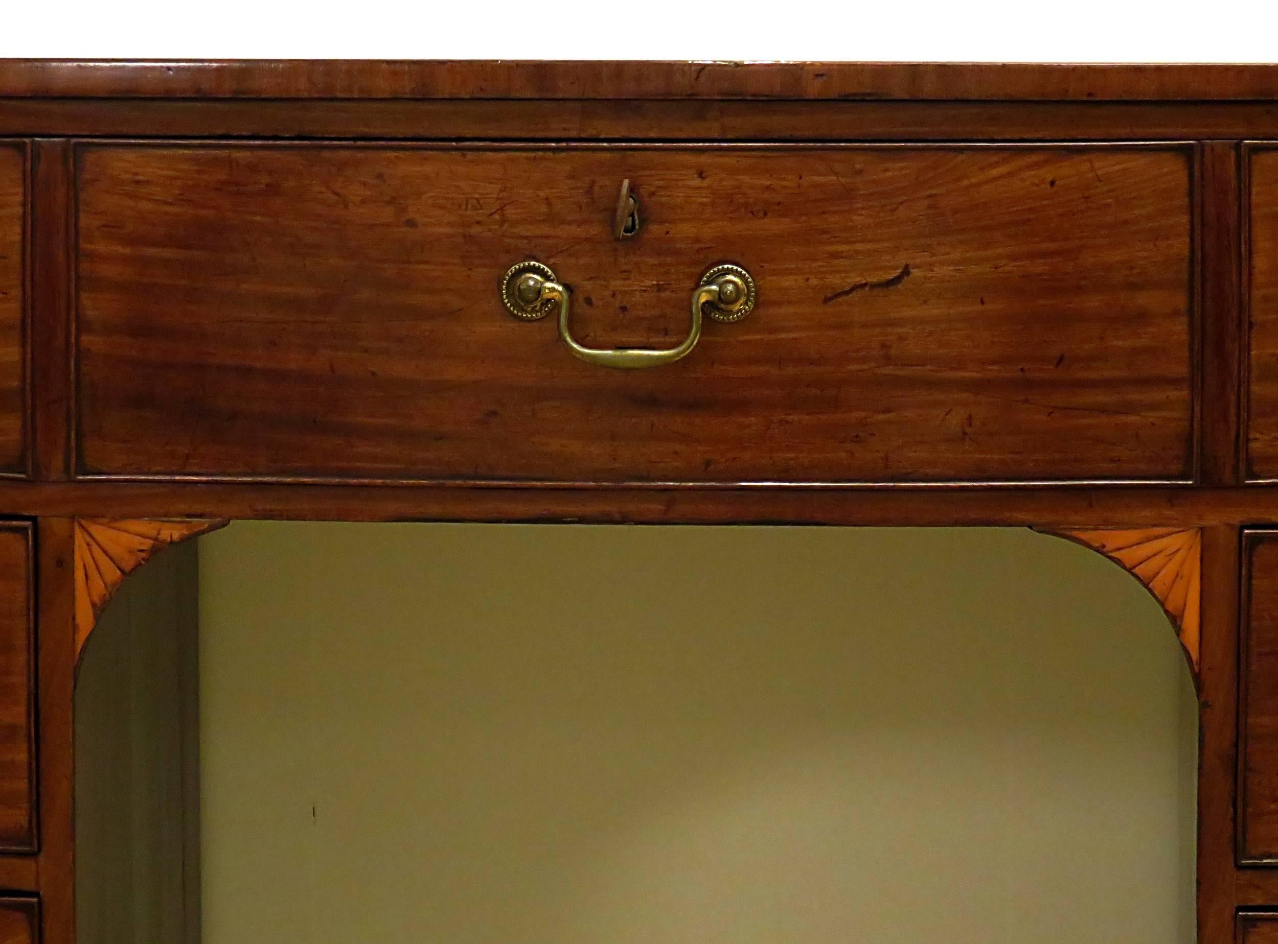 A very handsome and well-proportioned Georgian small sideboard or brandy board made in England late in the 18th century of well figured mahogany with satinwood spandrels and Chippendale swans neck pulls. From an old East Coast collection formed over