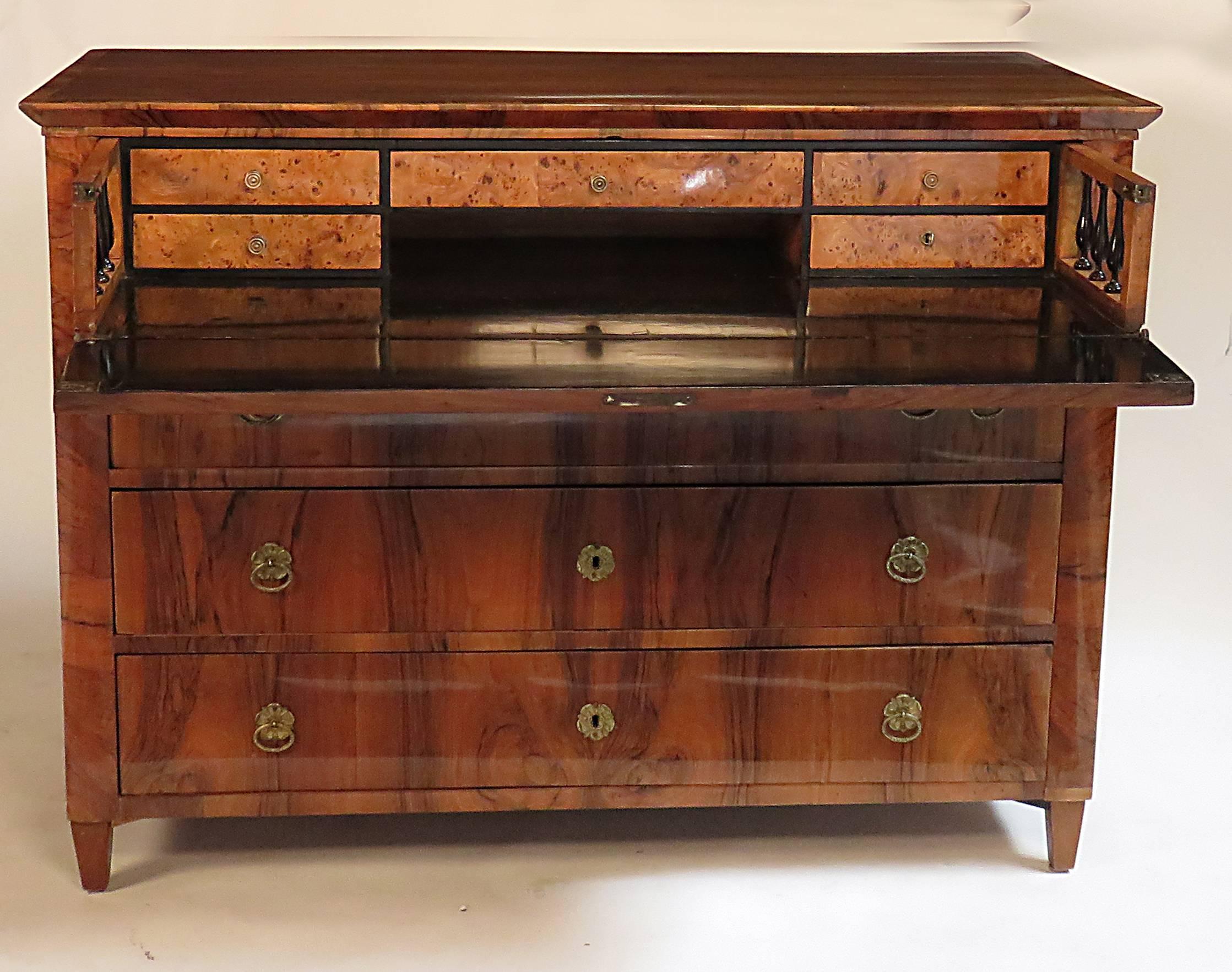 Tailored neoclassical figured walnut commode made in central Europe, probably Austria about 1830. Useful well fitted secretary drawer. Good larger size offering plenty of storage. The veneers are exceptional. The secretary drawer is ebonized with