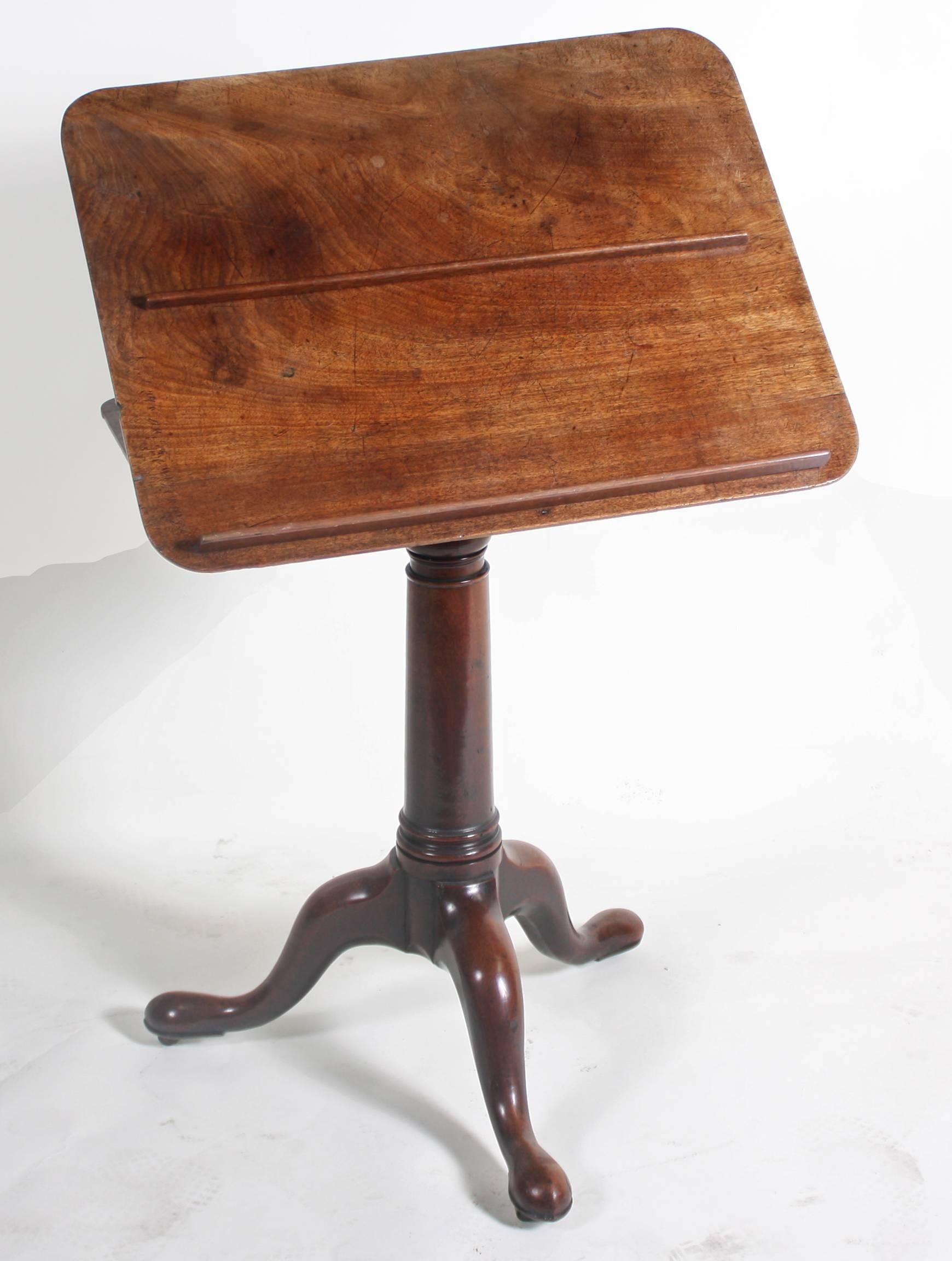 A small mahogany table with easel top to aid one in reading etc. Made in England or UK, circa 1750. Standing on graceful cabriole legs with casters. The rectangular top supported by a well turned and tapered pedestal. This table comes from the