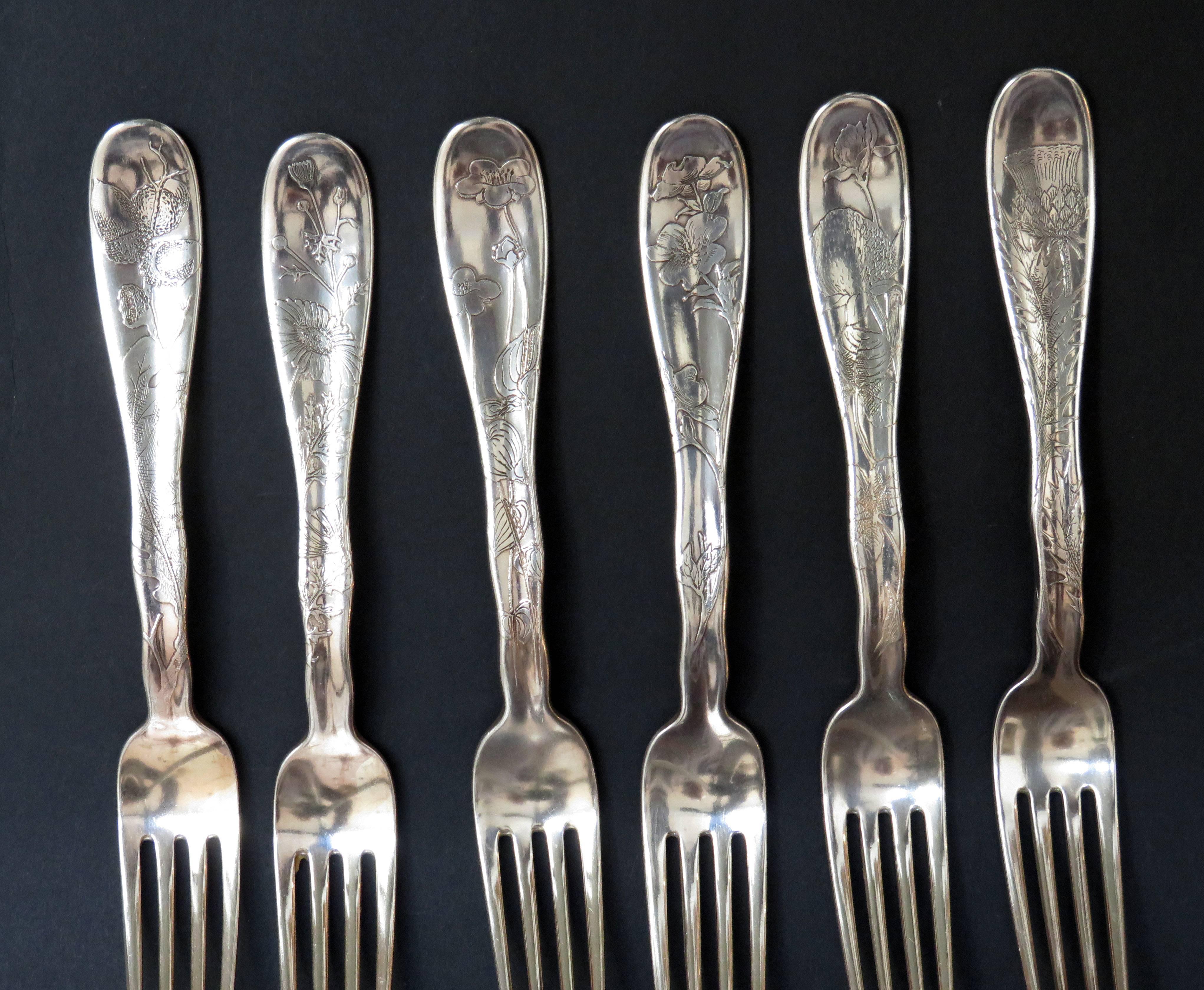 A set of 12 Tiffany & Company lap over edge acid etched dinner forks each etched with plants and flowers. 6 forks have a monogram of 