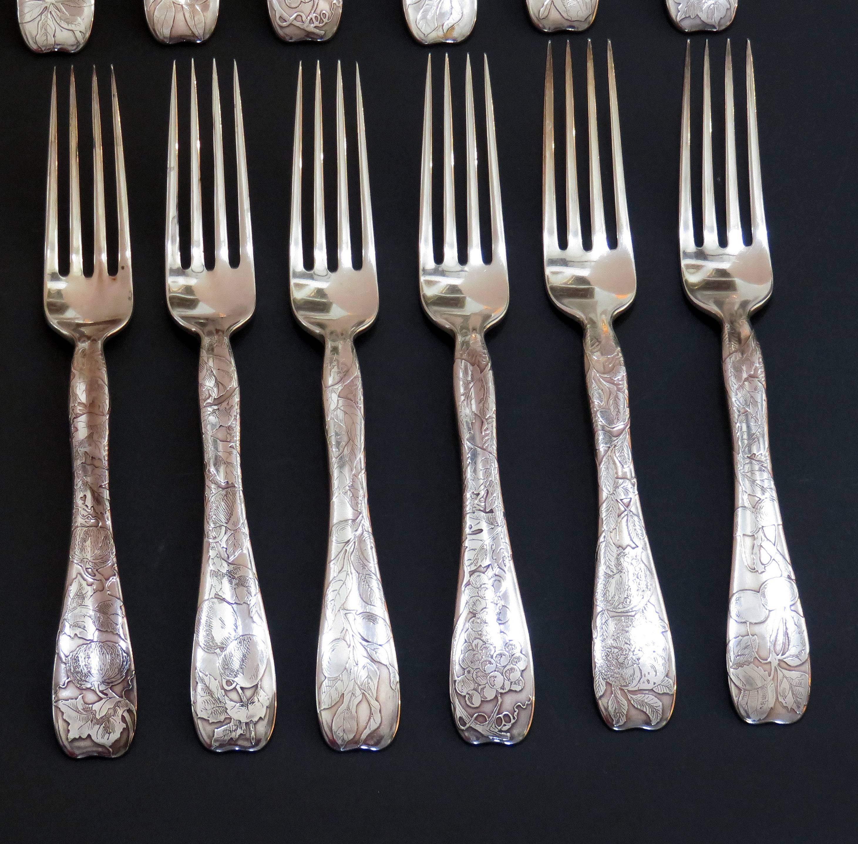 A set of 12 Tiffany & Co. lap over edge acid etched lunch forks each etched with different fruits. Each fork has the name of the fruit engraved on the back of each fork. Six of the forks are marked Tiffany & Co Sterling Pat 1880 with the date mark