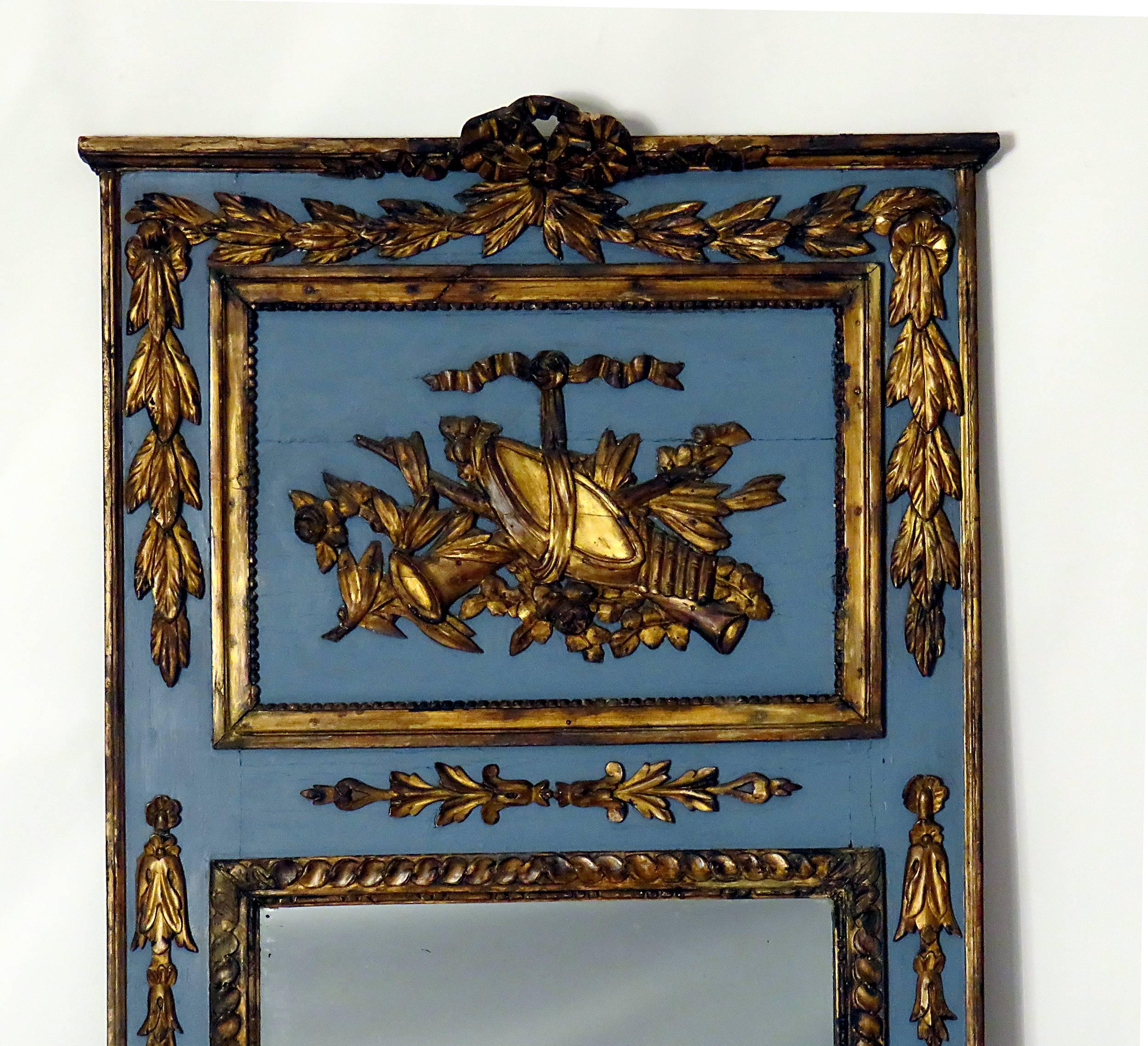 A handsome neoclassical mirror made in Sweden or France during the first part of the 19th century. The raised and gilt decoration is carved solid wood with some wear and old repairs to gilding along with some shrinkage. We loved the rich blue and