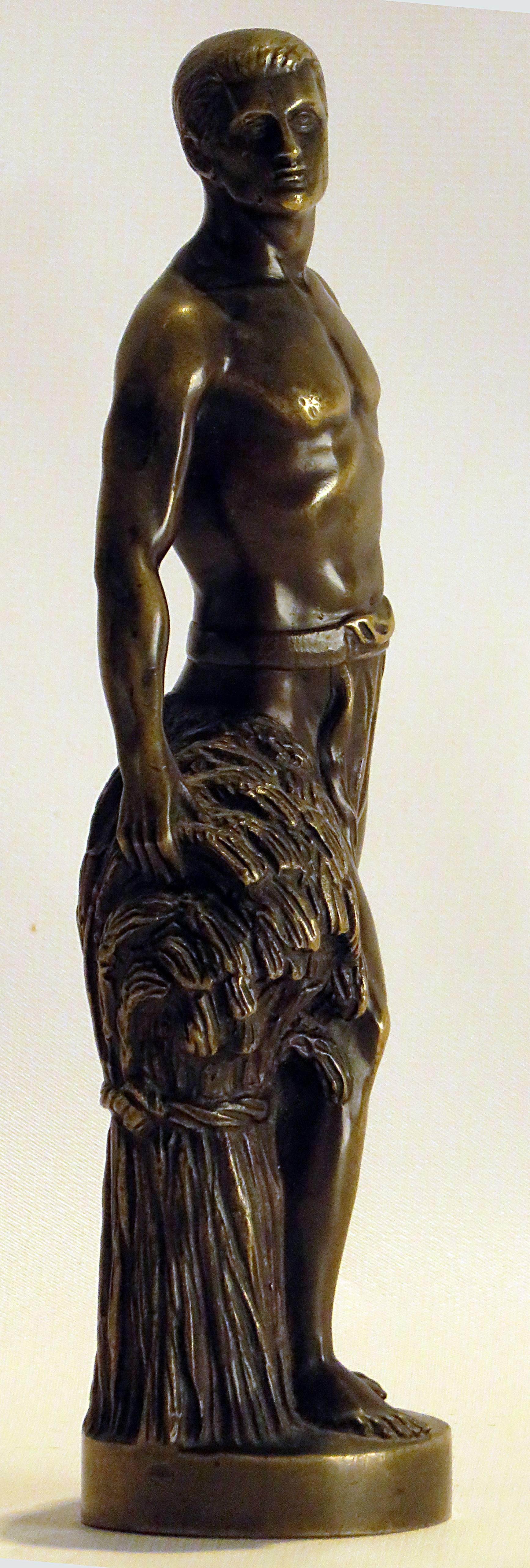 A well cast bronze figure of a muscular semi nude male standing next to a bundle of wheat. Artist signed but little information available on their work, late 19th century made in continental Europe, circa 1880.