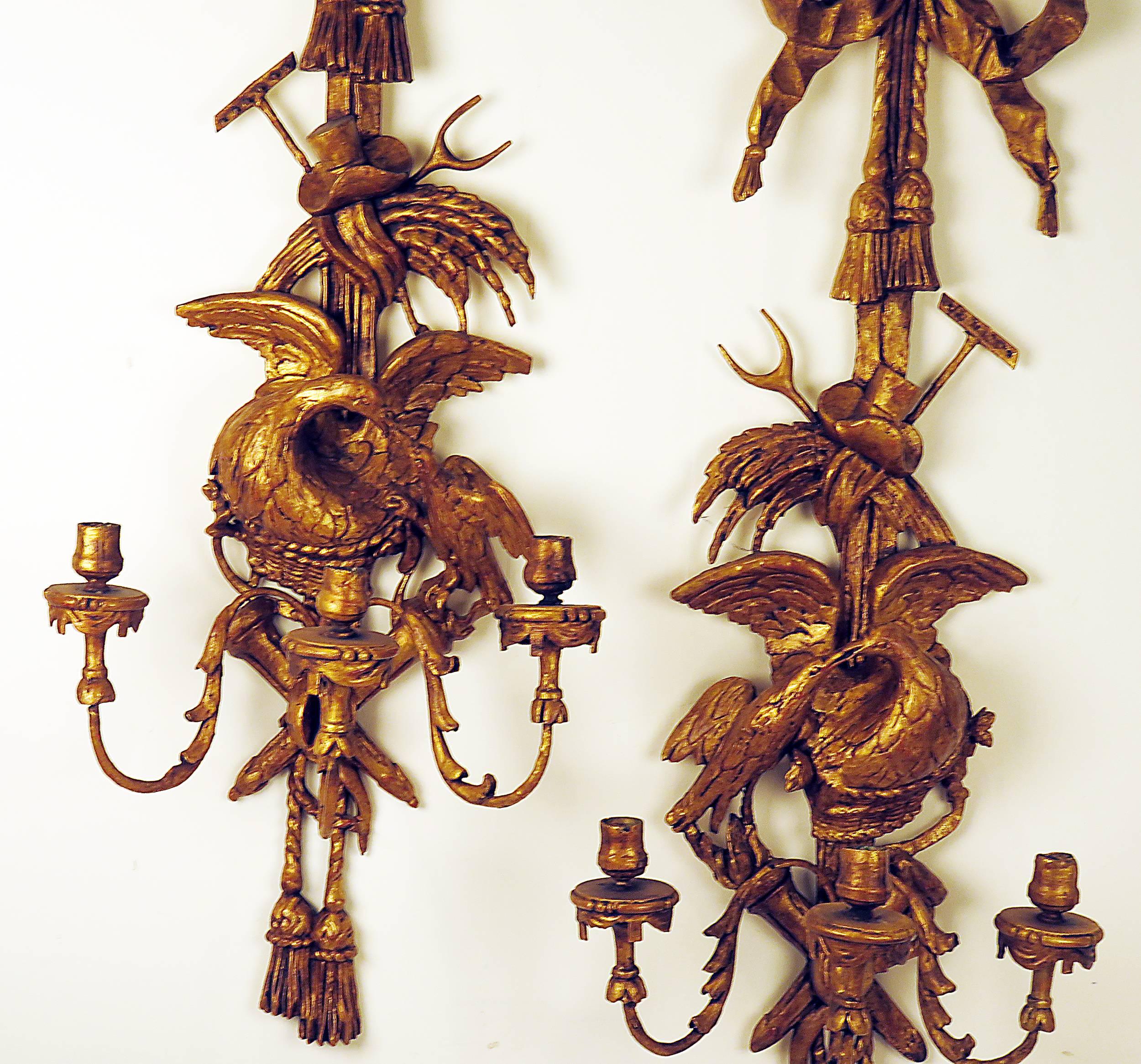 The large and elaborate pair of sconces was made circa 1880 in the Georgian Rococo style first made popular about 1750. We love the oversize scale and the quality of the carving. Featuring love birds with agricultural implements with bows swags and