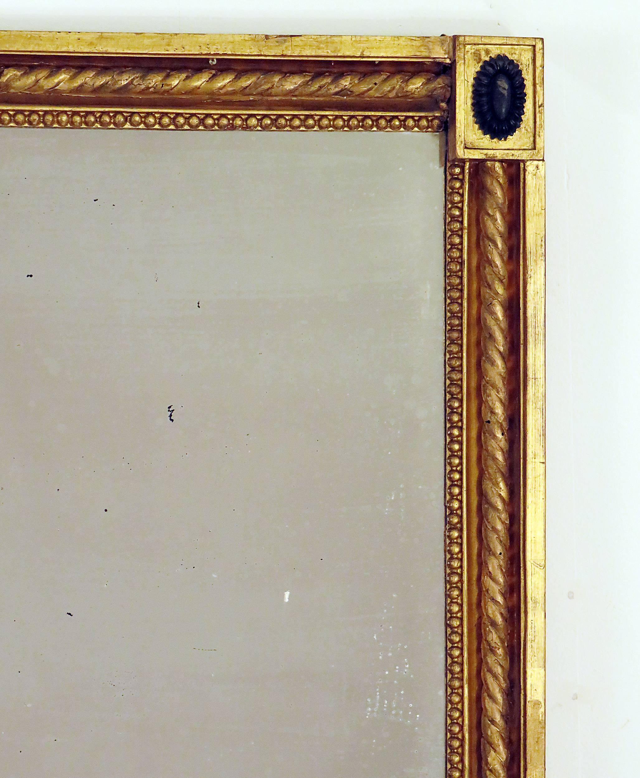 A sophisticated rectangular Swedish gilt and ebonized wood neoclassical mirror from the first part of the 19th century. The detailed giltwood carved rope twist with stylized oval flowers in the corners make this attribution easy. In good overall