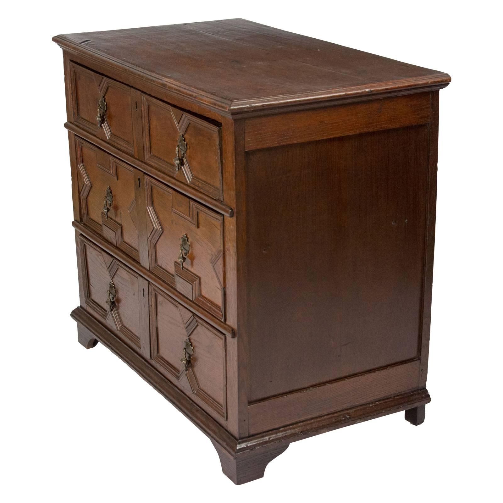 A Charles II small oak chest of drawers typical form with good geometrical panelling. Feet probably later. Drawers work well. Recently polished.