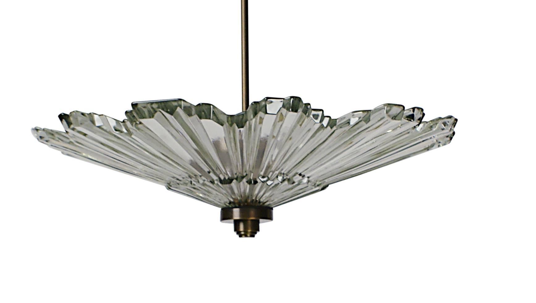 This elegant molded glass sun burst was made during the Art Deco period. This particular example is clear. Most of them where frosted. The electrical fittings are later and the wiring has been redone. A chic and unique piece for use in a smaller