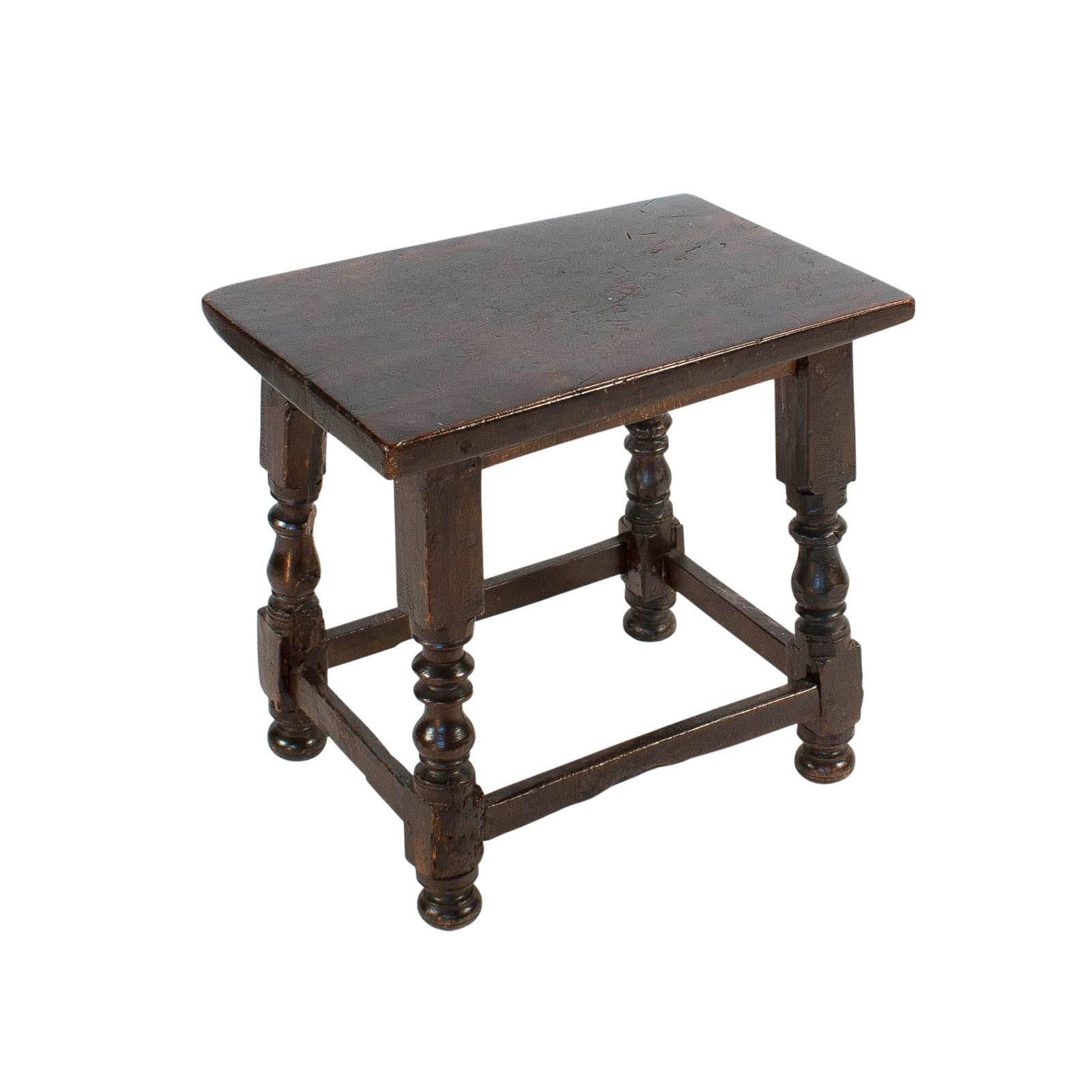 A handsome rustic walnut stool in the Baroque manner made in the country side in the 19th century or earlier in Italy or Spain. These pieces are wonderful side tables or can be used for seating. Lots of wear and patina. We love the quirky shape of
