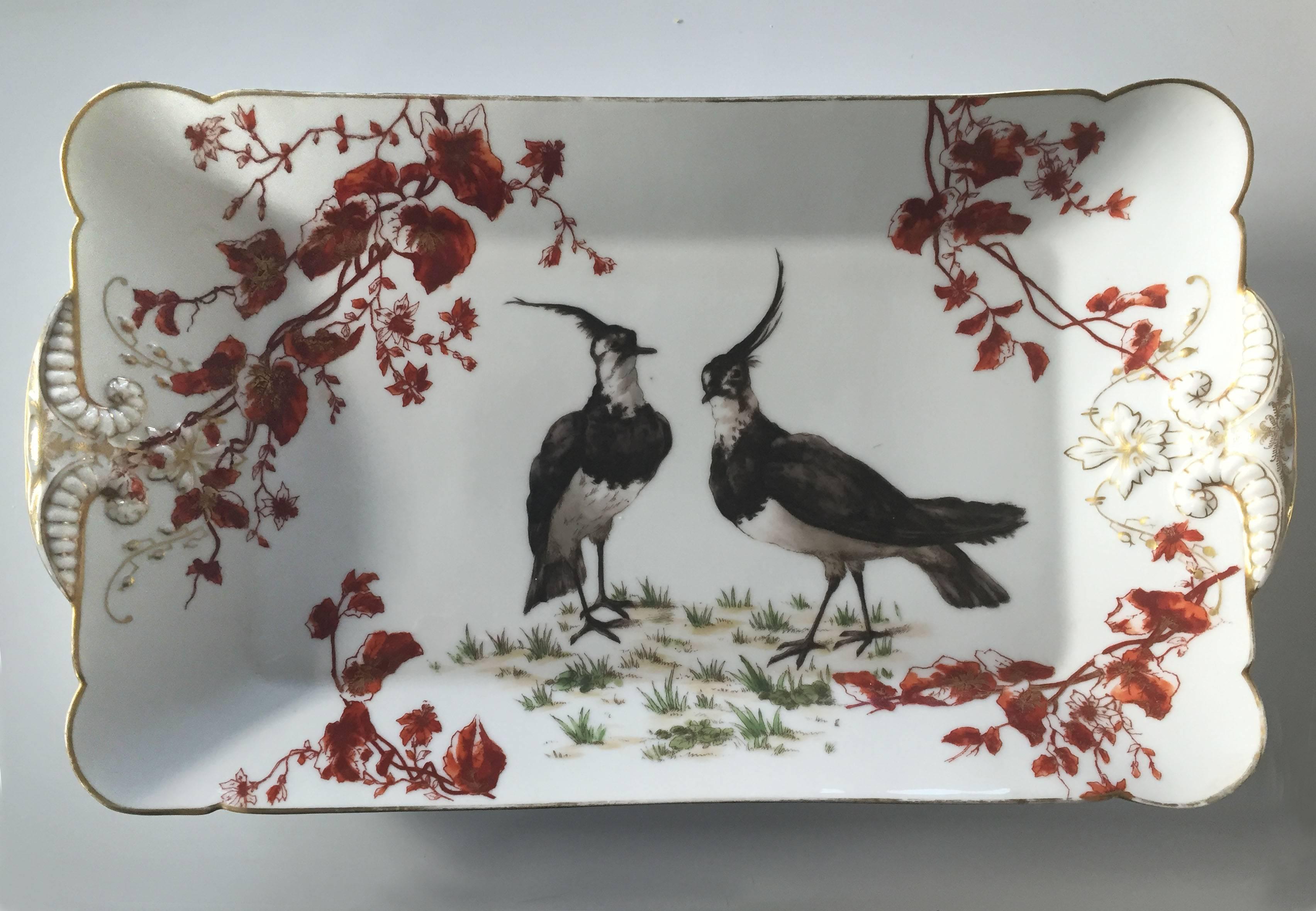 Gorgeous hand-painted platter by Charles Field Haviland, featuring two birds, surrounded by curling branches. The platter is marked by a manufacturer's stamp (CFH/GDM) on the bottom.