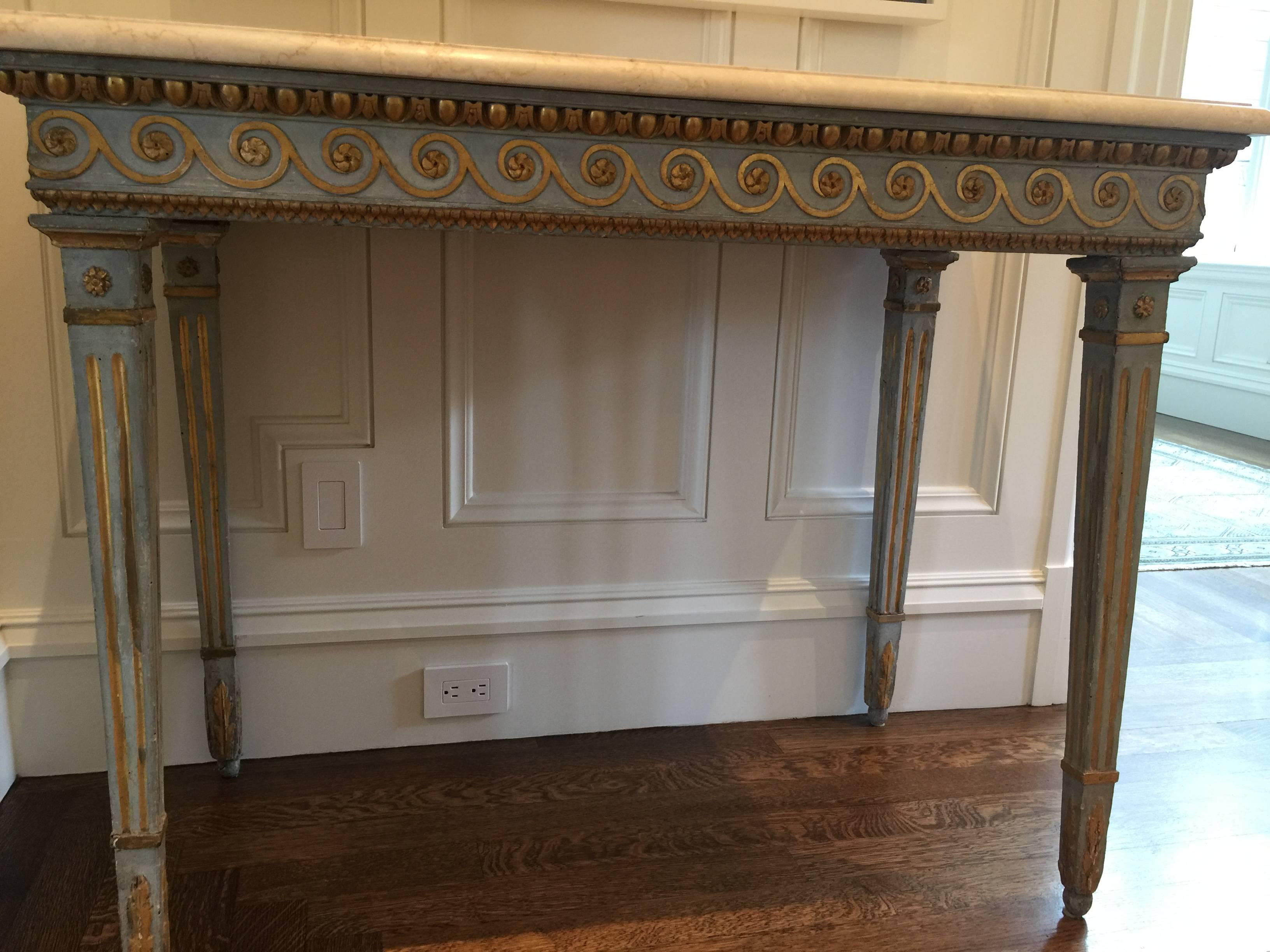 18th century hand-carved polychrome and giltwood Gustavian console table with marble top.
The apron carved with wave motifs with bead moldings top and bottom. The tapered fluted legs with banded rosettes and acanthus detailing on the