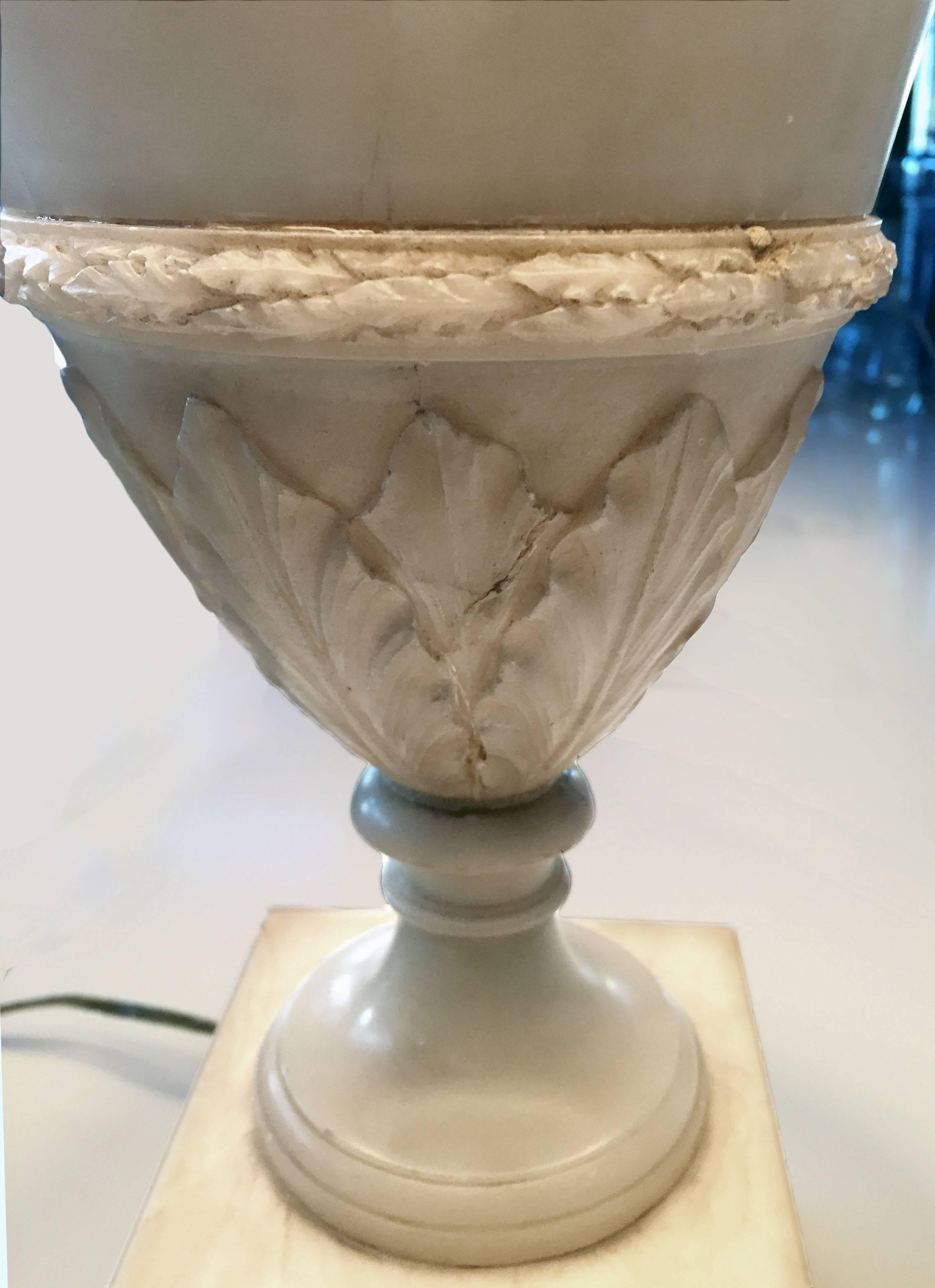 Late 19th century French alabaster lamp with custom trimmed silk shade. Hand-carved classic urn form with highly detailed carving of acanthus leaves and rosettes on double stepped base with gilding.
The shade is silk with custom trim. Completely