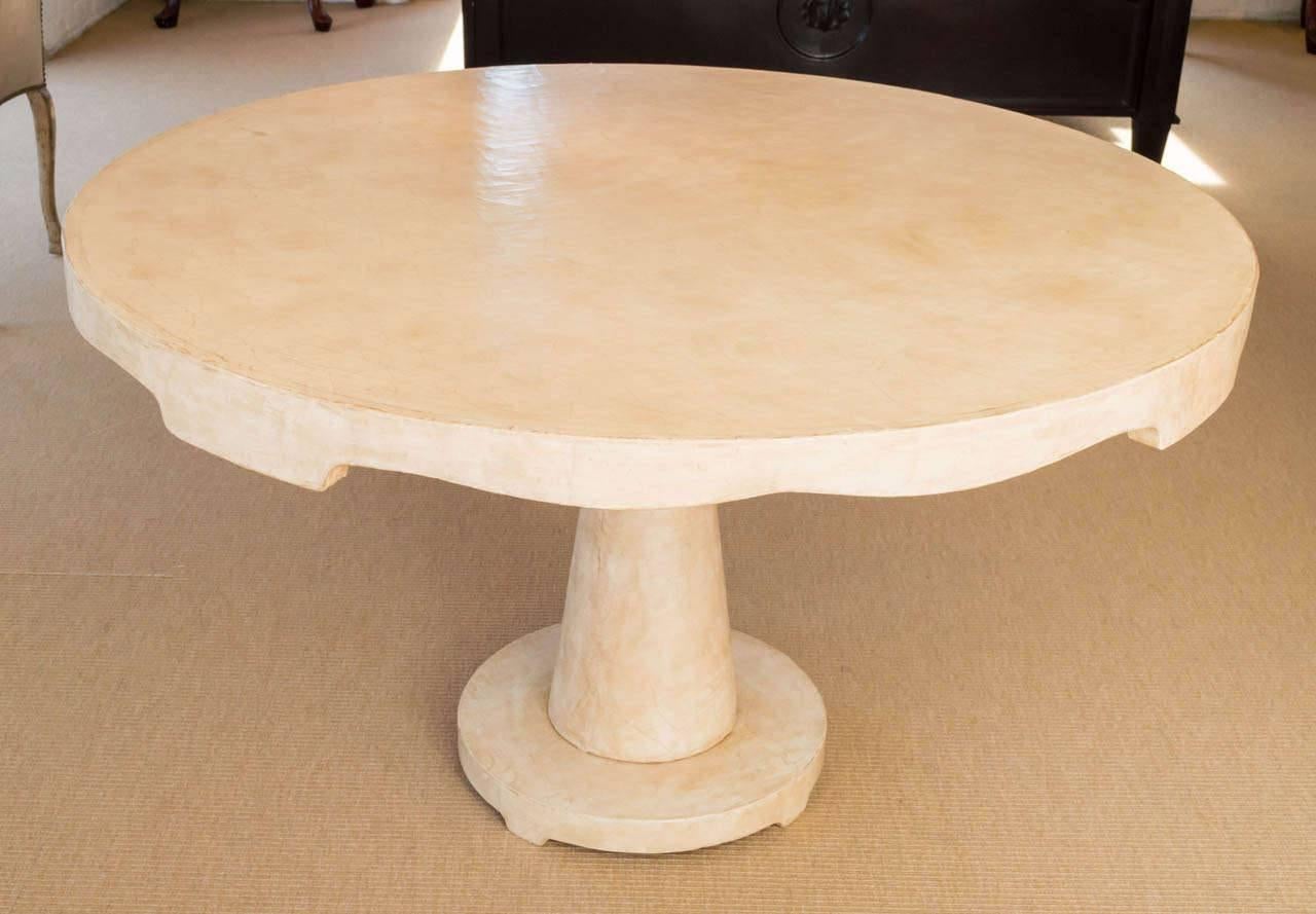 Candace Barnes Moroccan inspired round center table in an ivory crackled lacquer over canvas finish on a tapered base with scalloped apron raised on circular base. 
Available in different finish options, made to order.