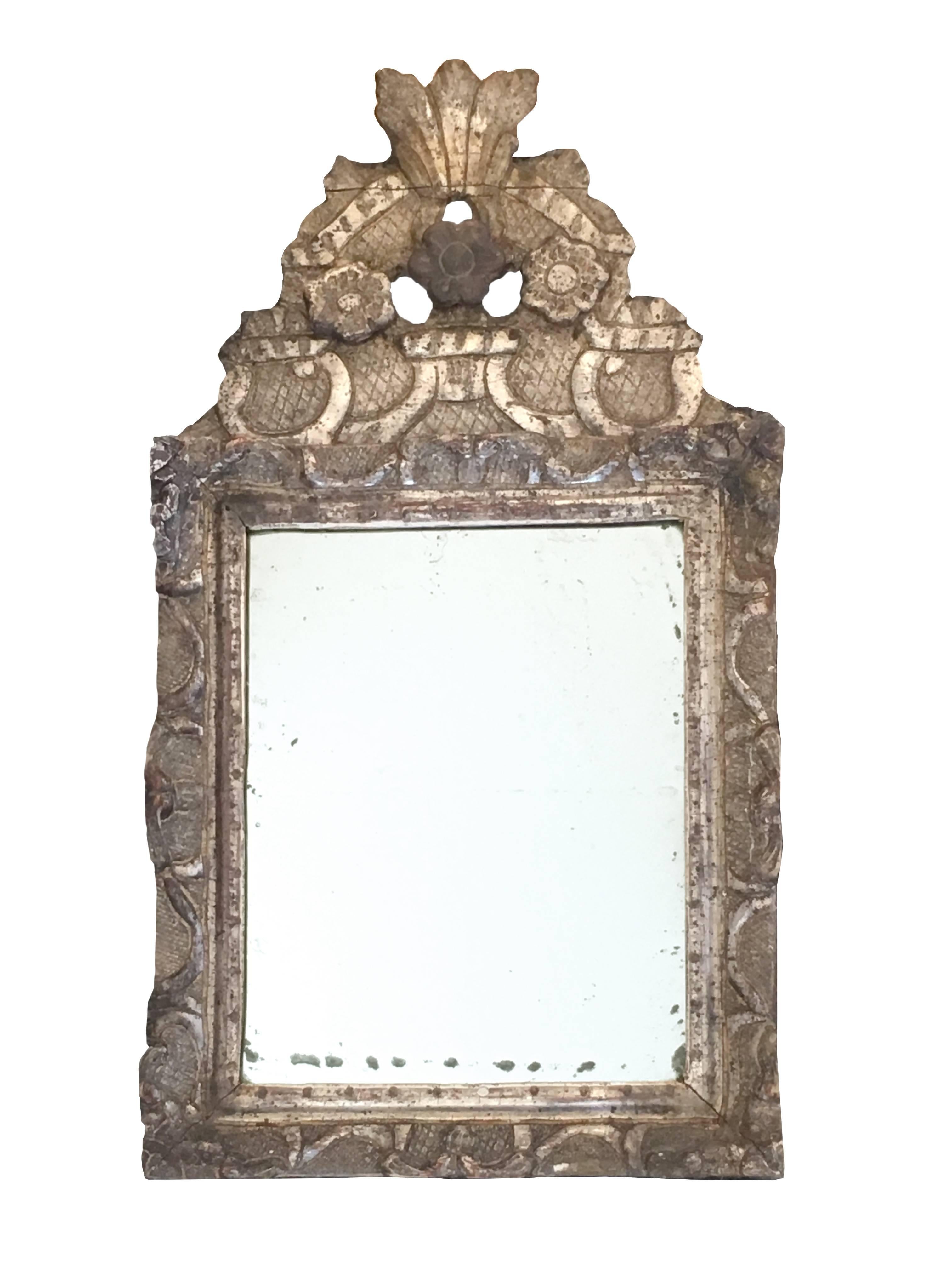 Beautiful small French Regence champagne leaf giltwood mirror with original mercury glass.The hand-carved front top and the frame, featuring three flowers.
French Regence period, early 18th century, circa 1710.
 