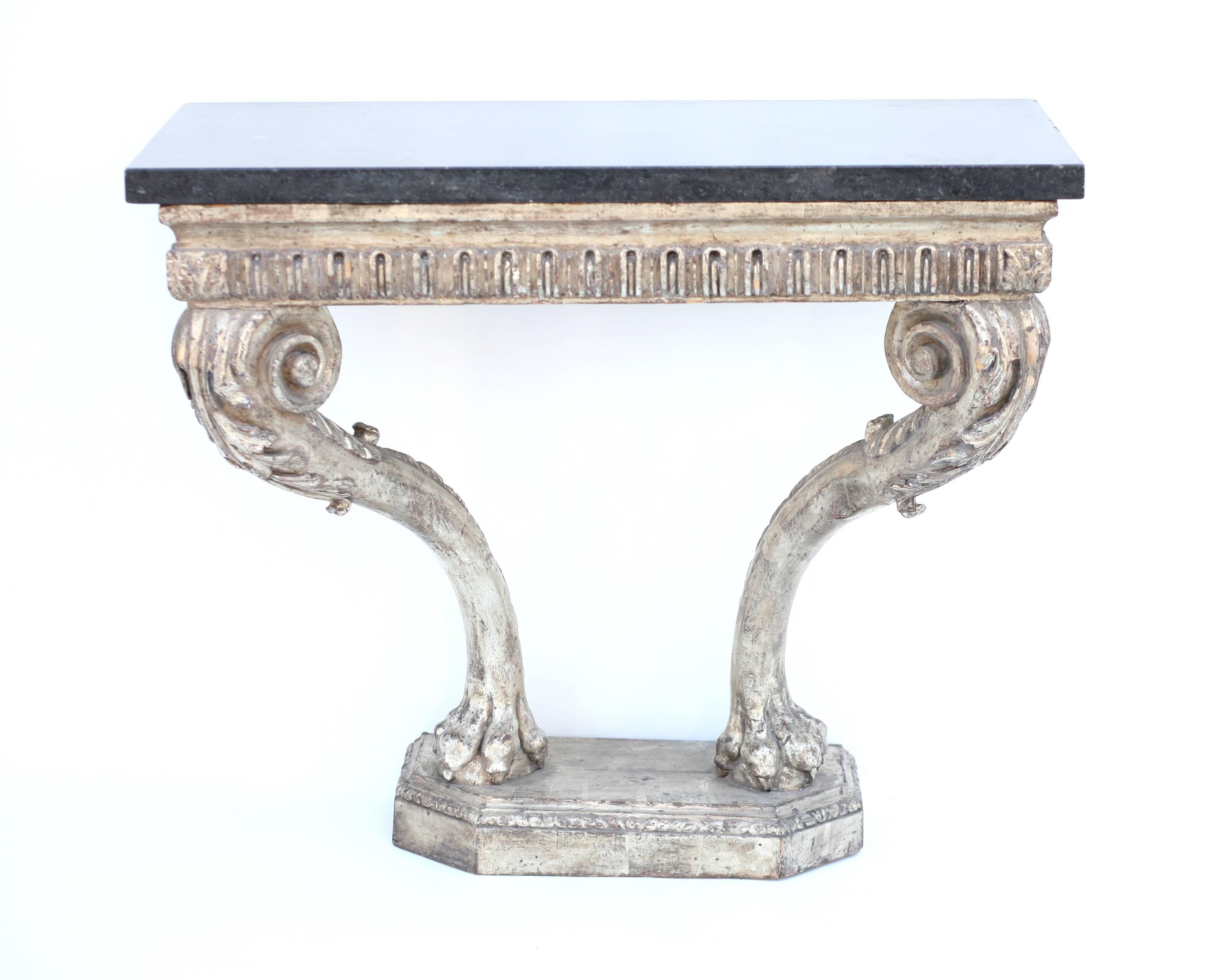 Mid-18th century beautiful period hand-carved George II console, the silver leafed apron with Classic arched fluted above stylized scrolling legs, the knees with carved acanthus culminating in lion paws on a stepped carved base with canted corners.