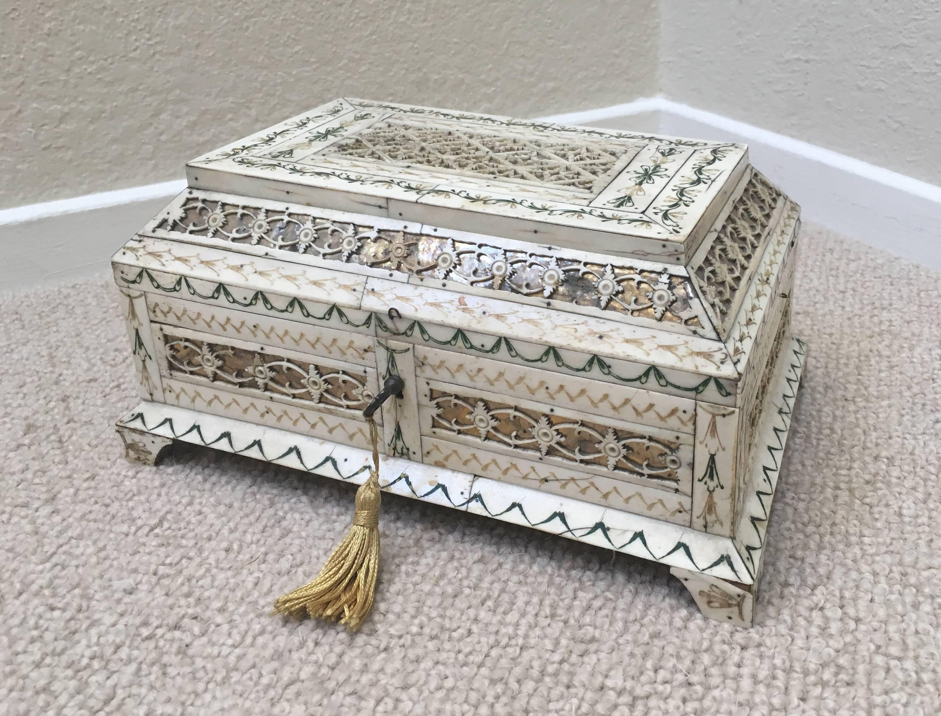Early 19th century Russian stained and hand-carved Bone Table Casket Kholmogory Box, veneered with panels of foliate engraved stained bone alternating with geometric and foliate fretwork panels over foil, raised on bracket feet. Including original
