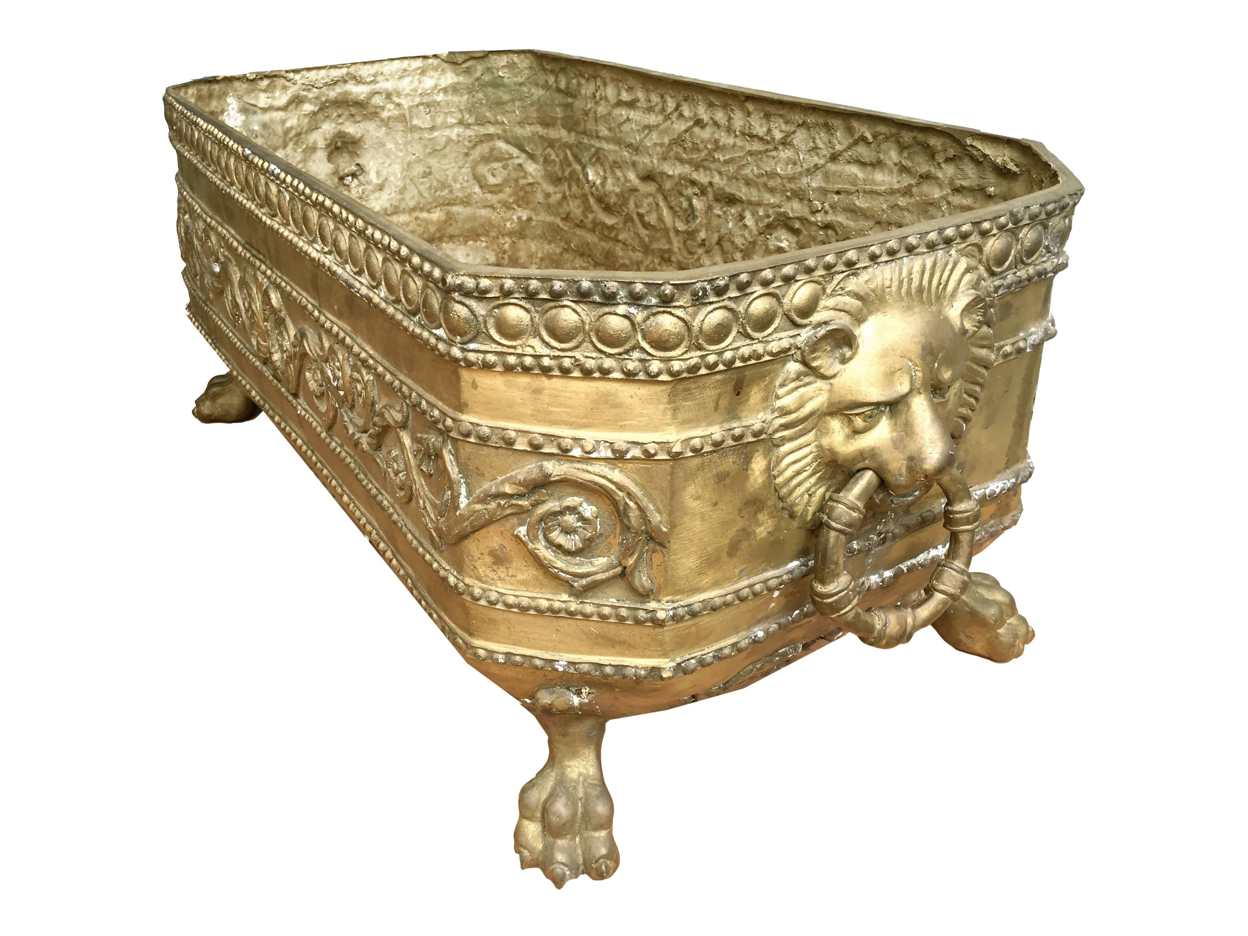19th century grand scale footed english antique brass jardiniere with lion's heads, classical beading and scrolling vines. The whole raised on lion's paw feet.

This is a very large beautiful piece with great patina.
