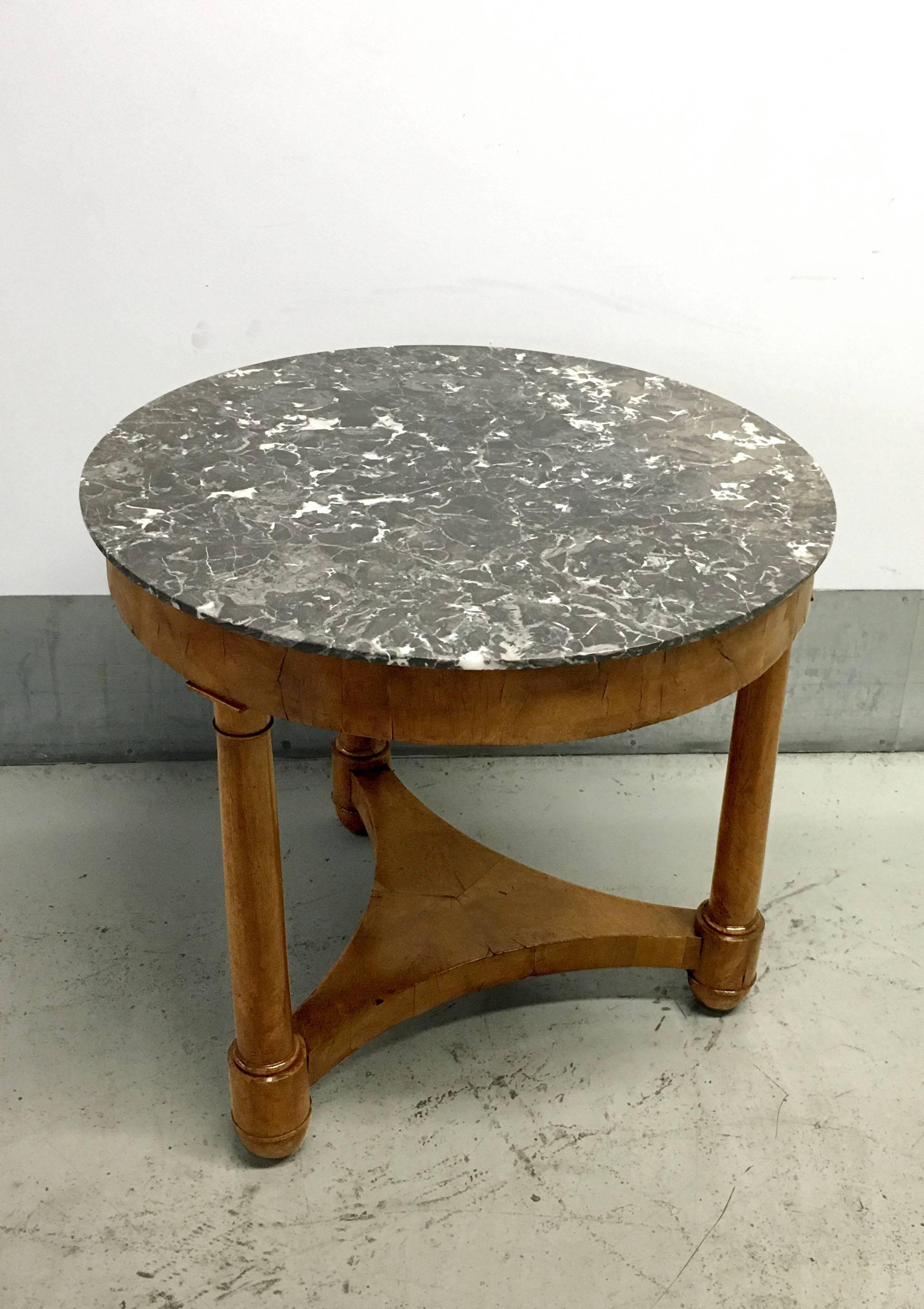 19th century Louis Philippe elmwood round table with marble top. The base is comprised of three tapered legs with a triangular support shelf. The gray marble top has white veining and the elmwood is burled and figural.