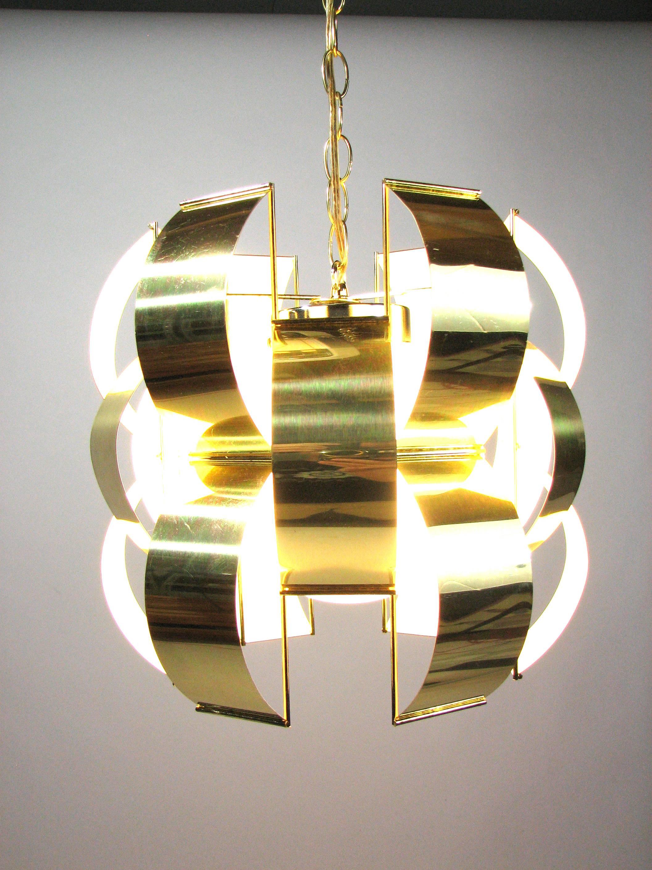Polished brass "ribbons" enclose a single lamp in an opaque white globe at the center of this iconic Mid-Century Lightolier pendant light - an homage to 1960s lighting designer Max Sauze. The soft atmospheric glow and open downright make