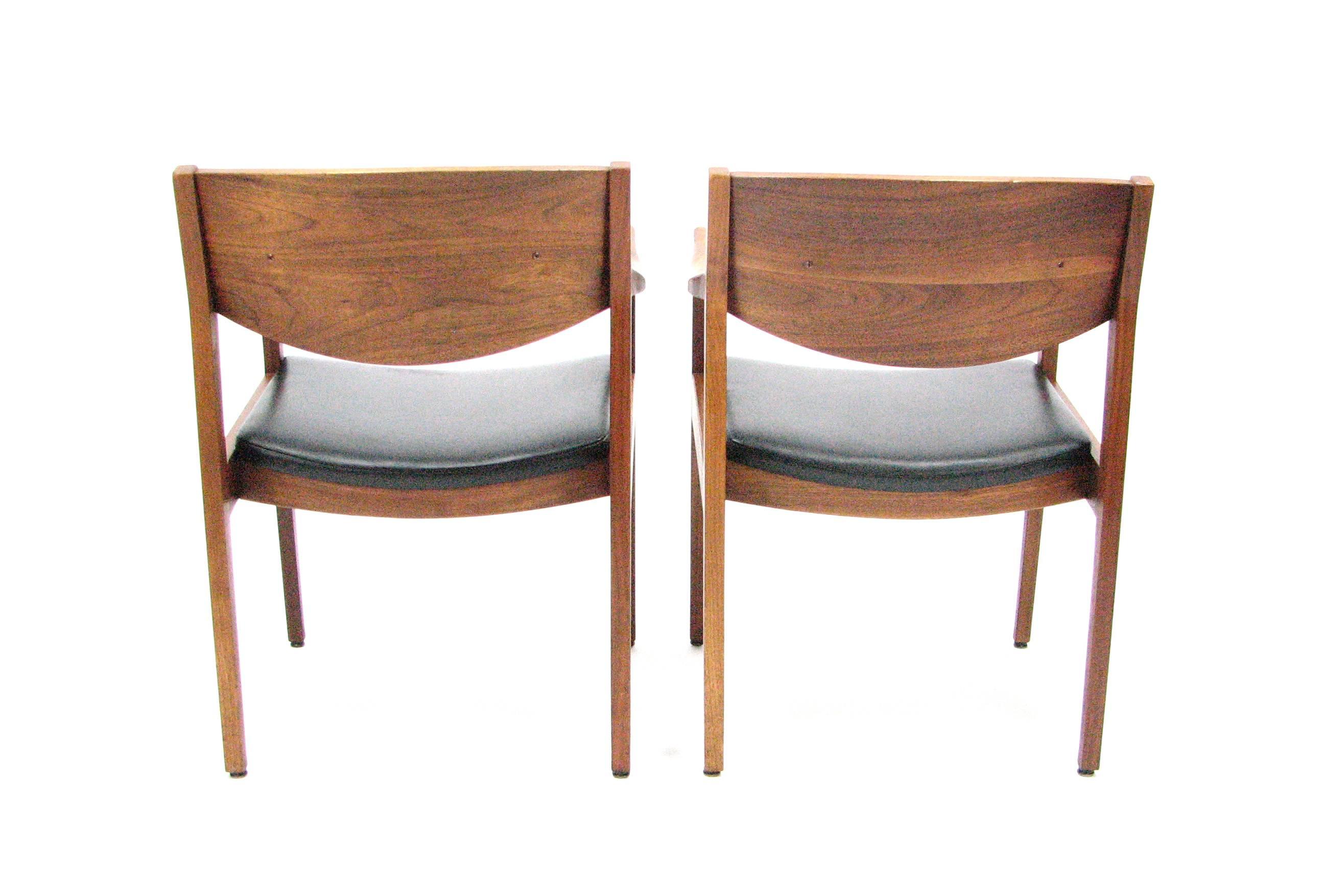 This pair of remarkably comfortable Mid-Century chairs in the manner of Jens Risom was produced by Gunlocke in the 1950s.  Beautifully grained walnut with Naugahyde upholstery.