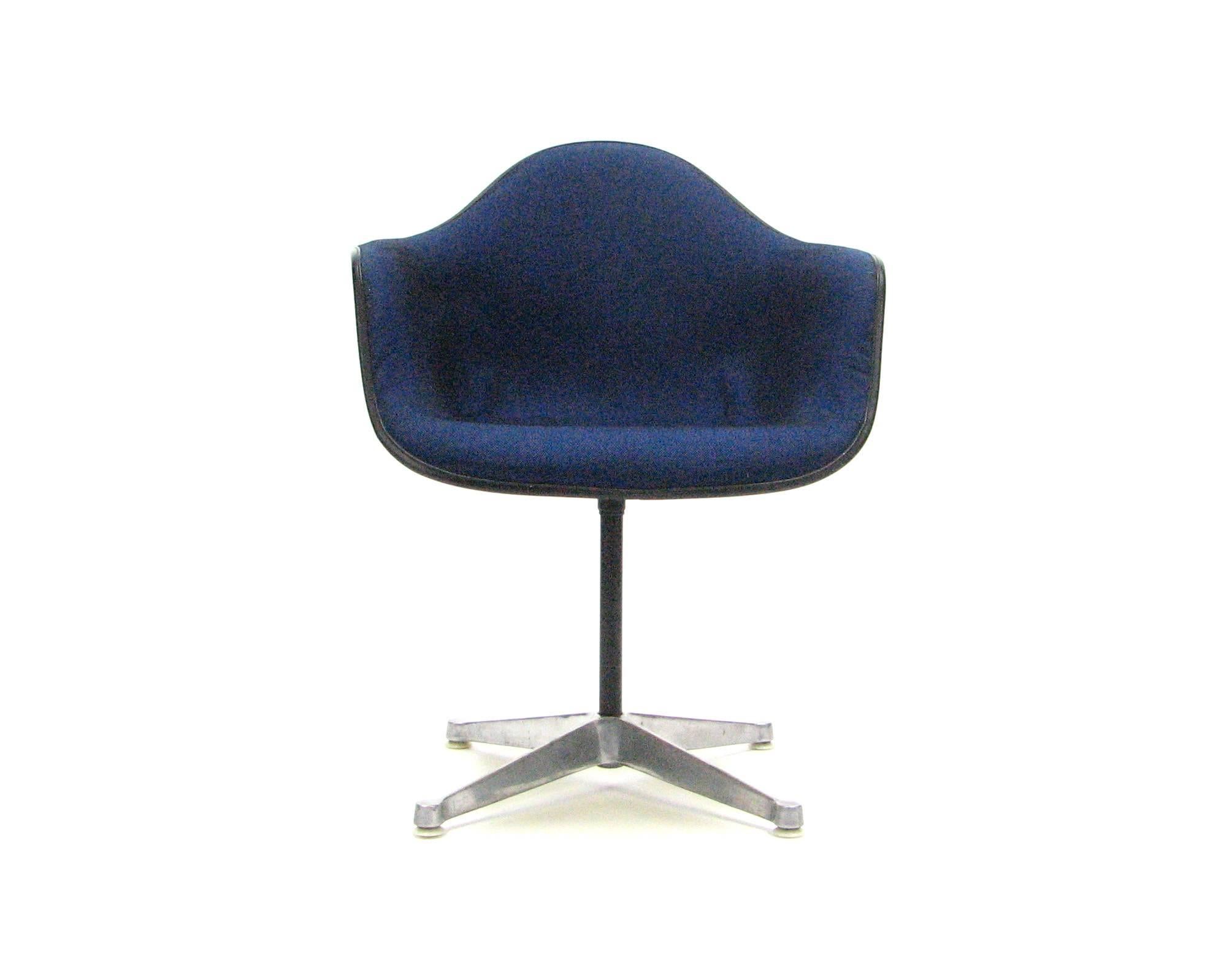 Striking, cheerful and iconic, this bright yellow molded fiberglass swivel armchair by Charles and Ray Eames for Herman Miller is upholstered in original heathered royal blue and black hopsack by Alexander Girard, early 1970s.

The fabric on