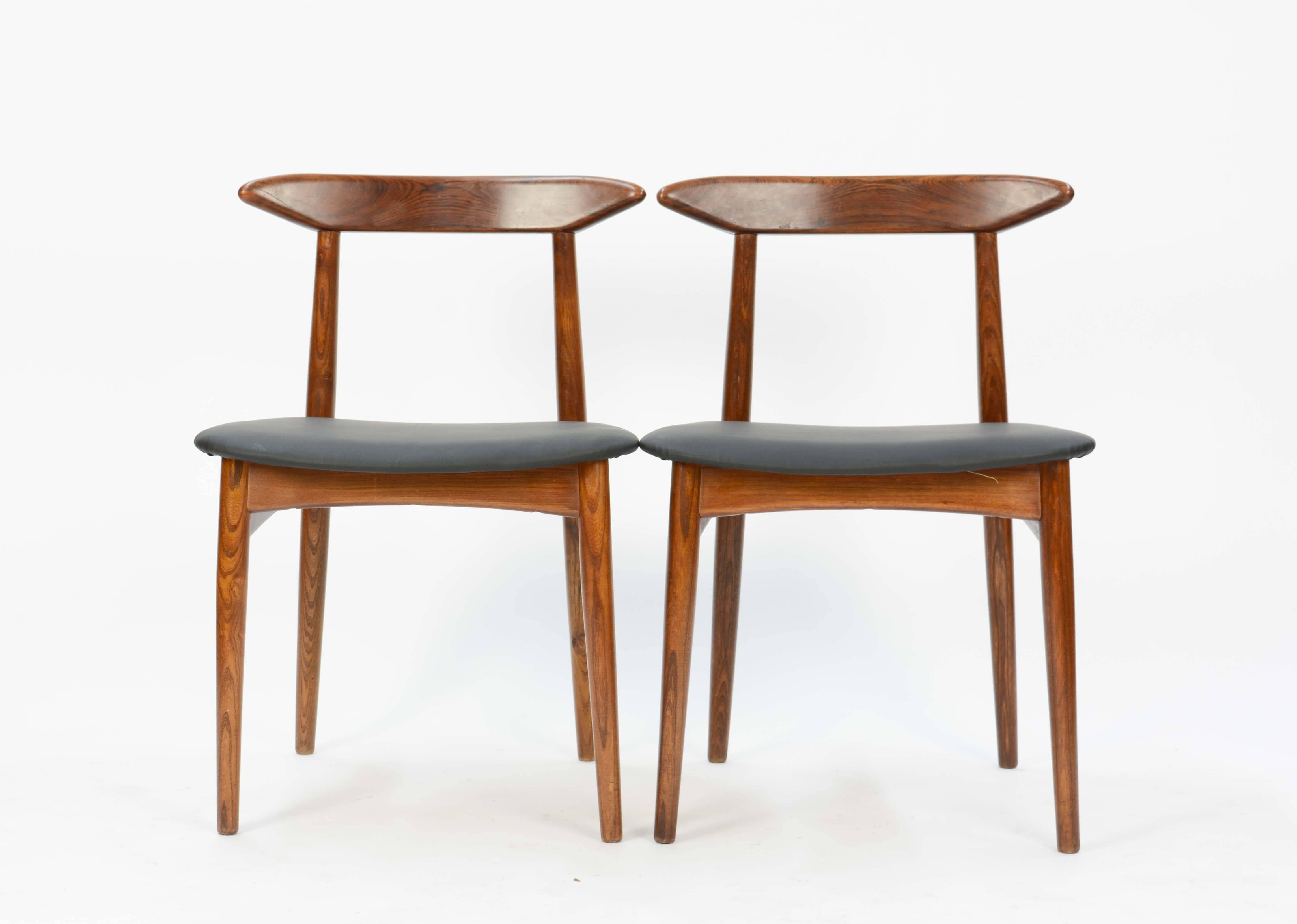 A wonderful set of 4 Danish Teak Dining Chairs After Hans Wegner .  The seat have been upholstered in a faux leather.