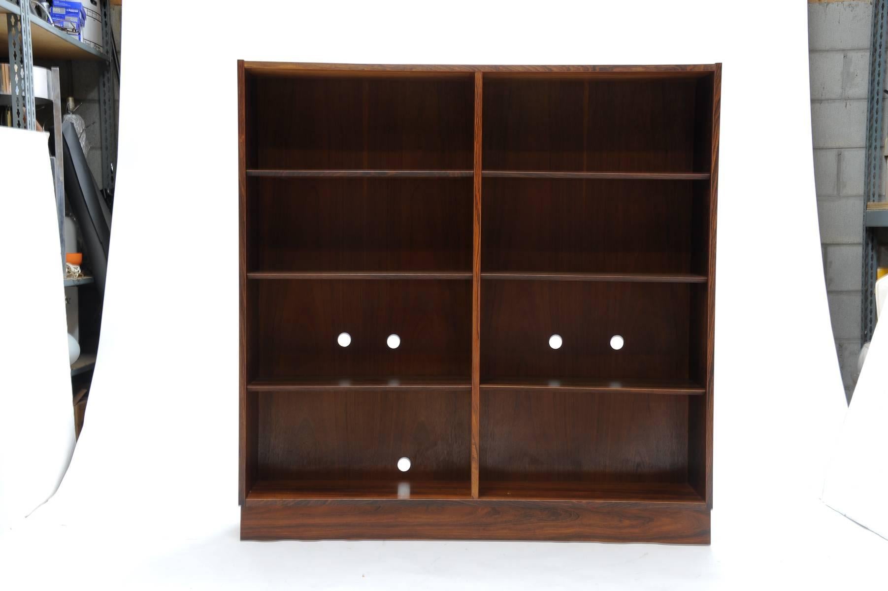 This is a wonderful pair of book cases by Danish architect Carlo Jensen for Domus Danica for Hundevad & Co of Ulfborg of Denmark. The book cases are each individually beautifully grained in Brazilian Rosewood. One case has holes for media outlet