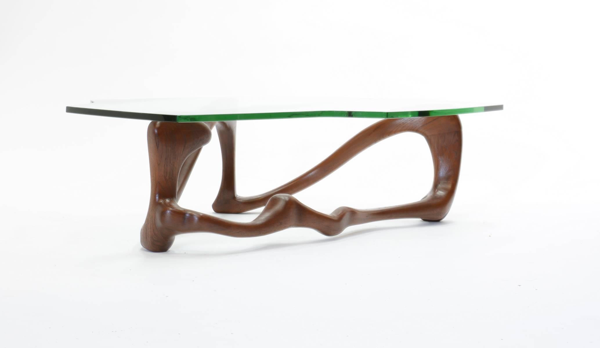 A mysterious and playful serpentine coffee table in the manner of the great CA wood carver of Northern California. Glass have chips to the edge and base could be shipped without and recreated local upon delivery.