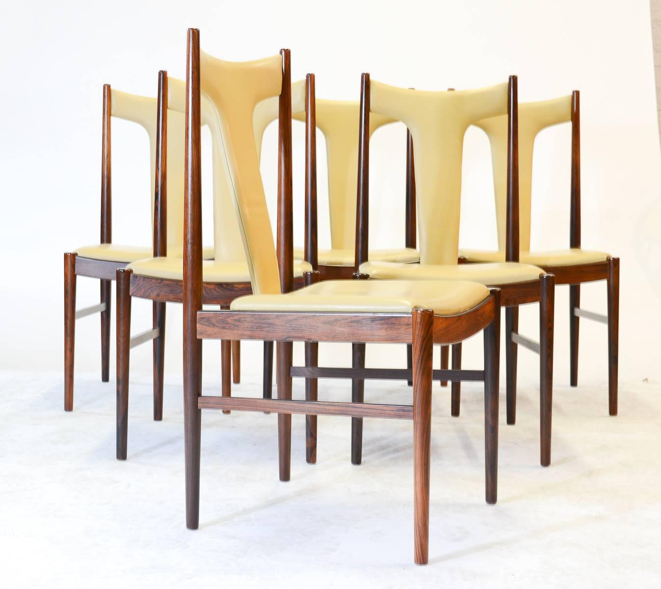 Six rare and magnificent high back dining chairs in rosewood and butter leather by Arne Vodder for Sibast of Denmark. Vodder's classic style mimicking natural forms is present here in the simple, yet dramatic slope of the back support.

Vodder's