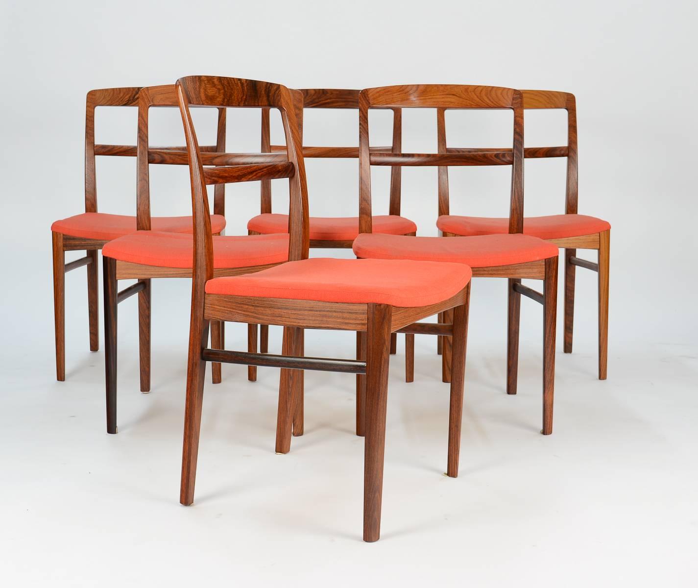 A distinctive set of six Danish rosewood dining chairs with dramatic red cushions. A supreme example of Vodder's simple grace that makes for enduring and highly sought-after design. Manufacturer Sibast Mobler's execution demonstrates fine
