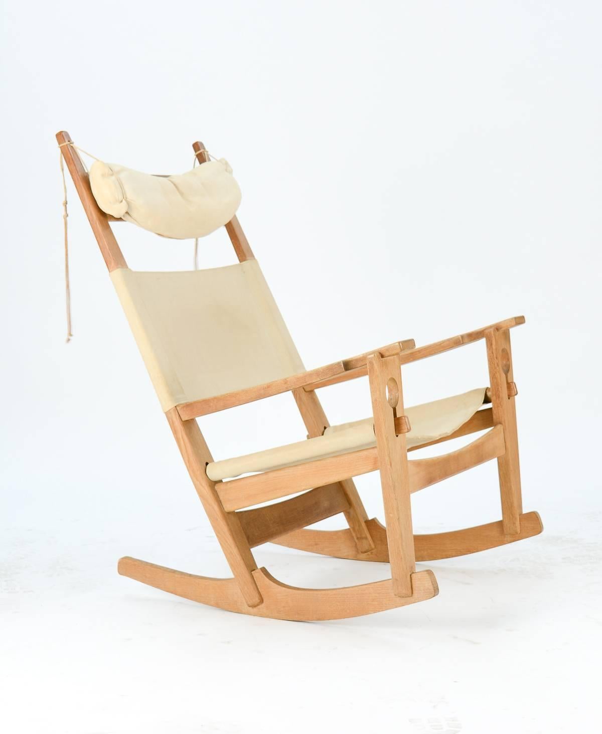 Esteemed Mid-Century Danish designer Hans Wegner's signature Key Hole rocking chair in oak with beige linen upholstery. 

Manufactured by GETAMA of Copenhagen, established 1899.

Recently imported from Denmark.

Arm height is 24 inches.