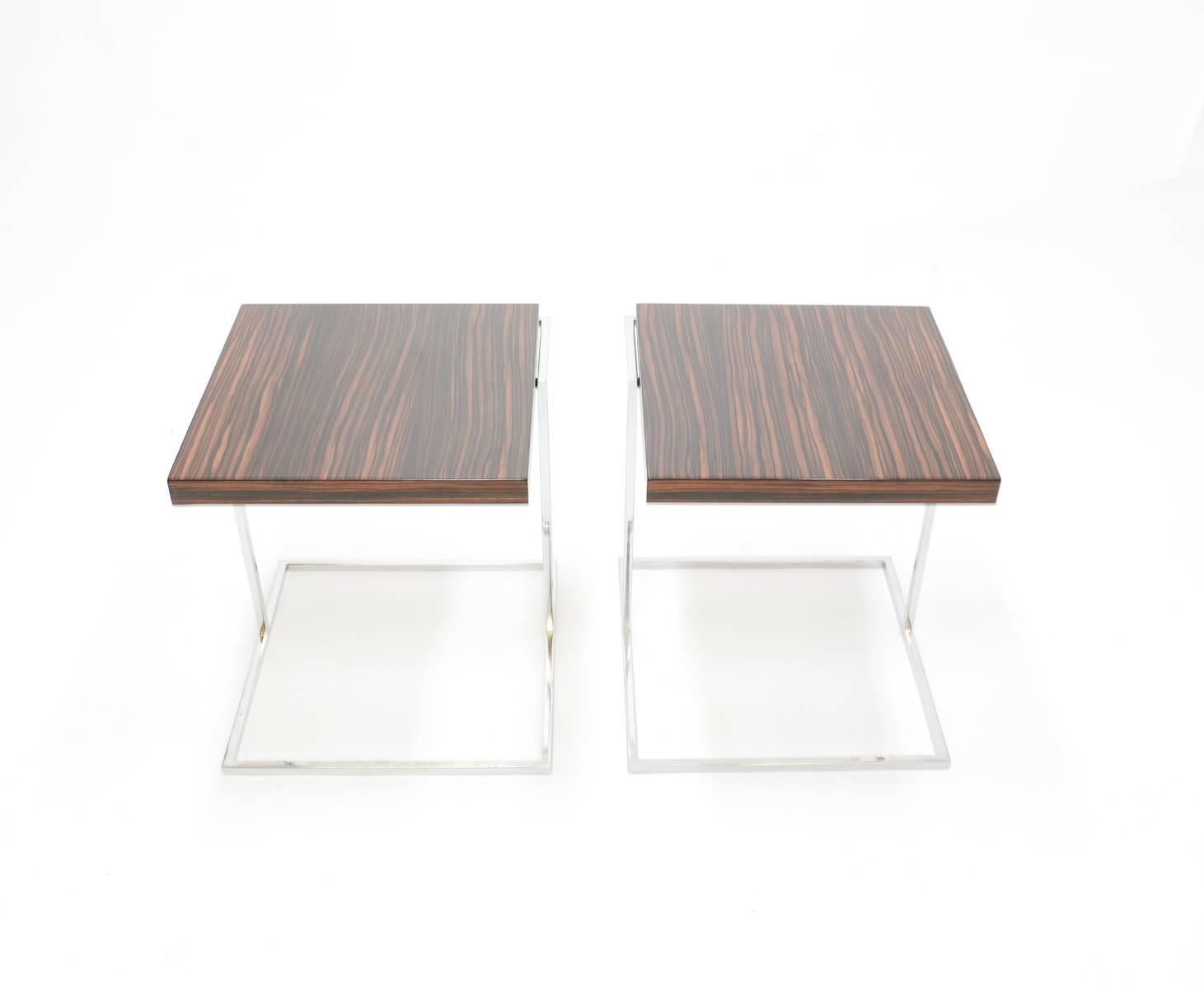 A pair of stunning zebra wood and chrome cantilever side tables. Their graceful cantilever design delivers strength, symmetry and simplicity while the zebra wood tops perfect each one with complimentary but unique natural patterns and shading.
 