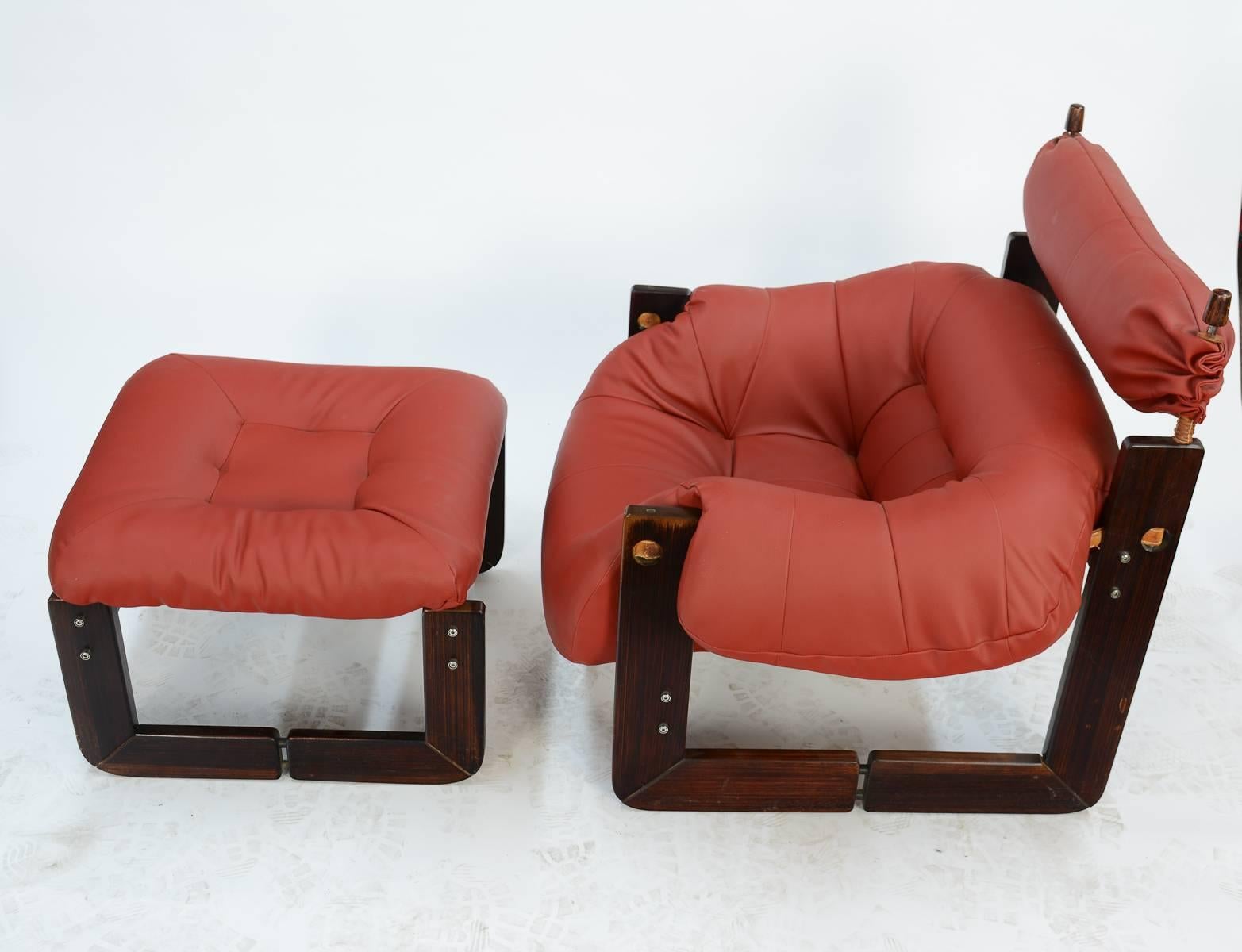 A delightfully beckoning Percival Lafer club chair and ottoman in rosewood with new red leather. Incredibly comfortable, ingenious design. Brazil, 1970s.

Ottoman measures 17 inches H x 24 inches W x 24 inches D.