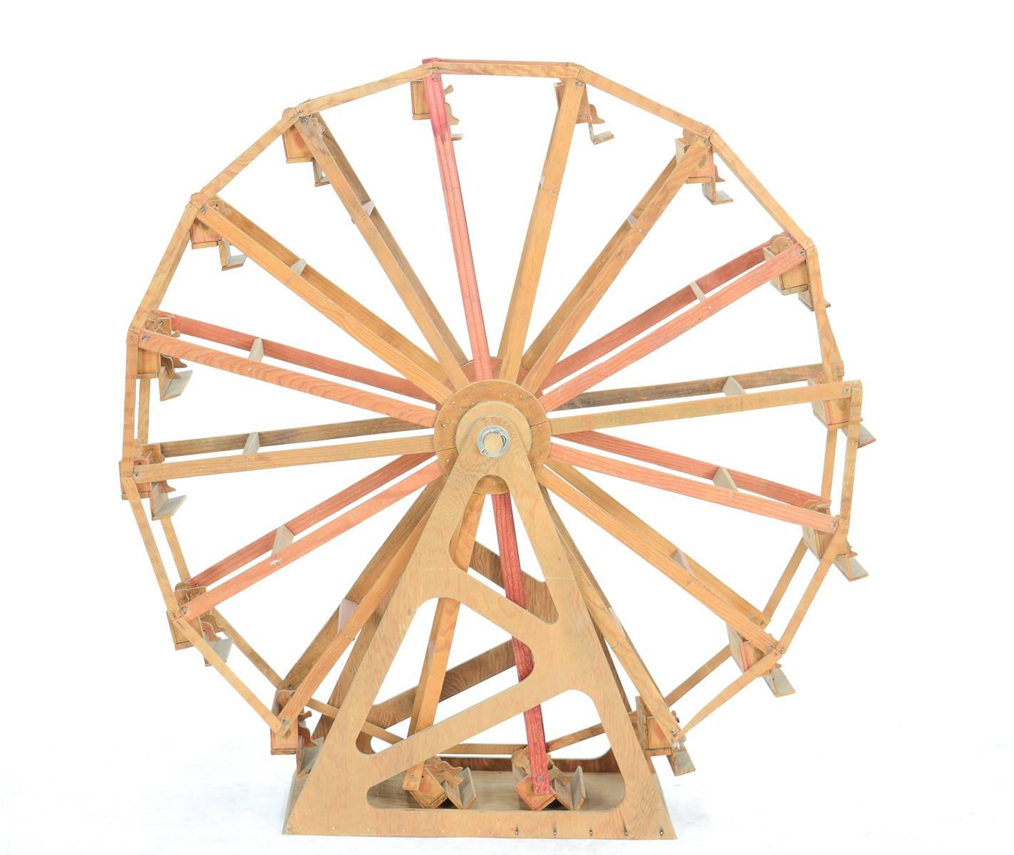 A monumental 43-inch Folk Art Ferris wheel made of orange crate wood, discovered in a Masonic Hall sale in Colorado.

Note the eye of horus-like feature on the Ferris wheel passengers

See image 7 for scale.