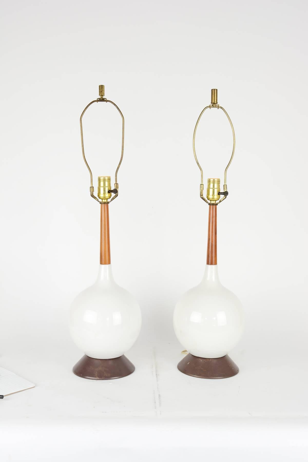 A pair of simple and elegant Danish blown-glass lamps with teak stems.