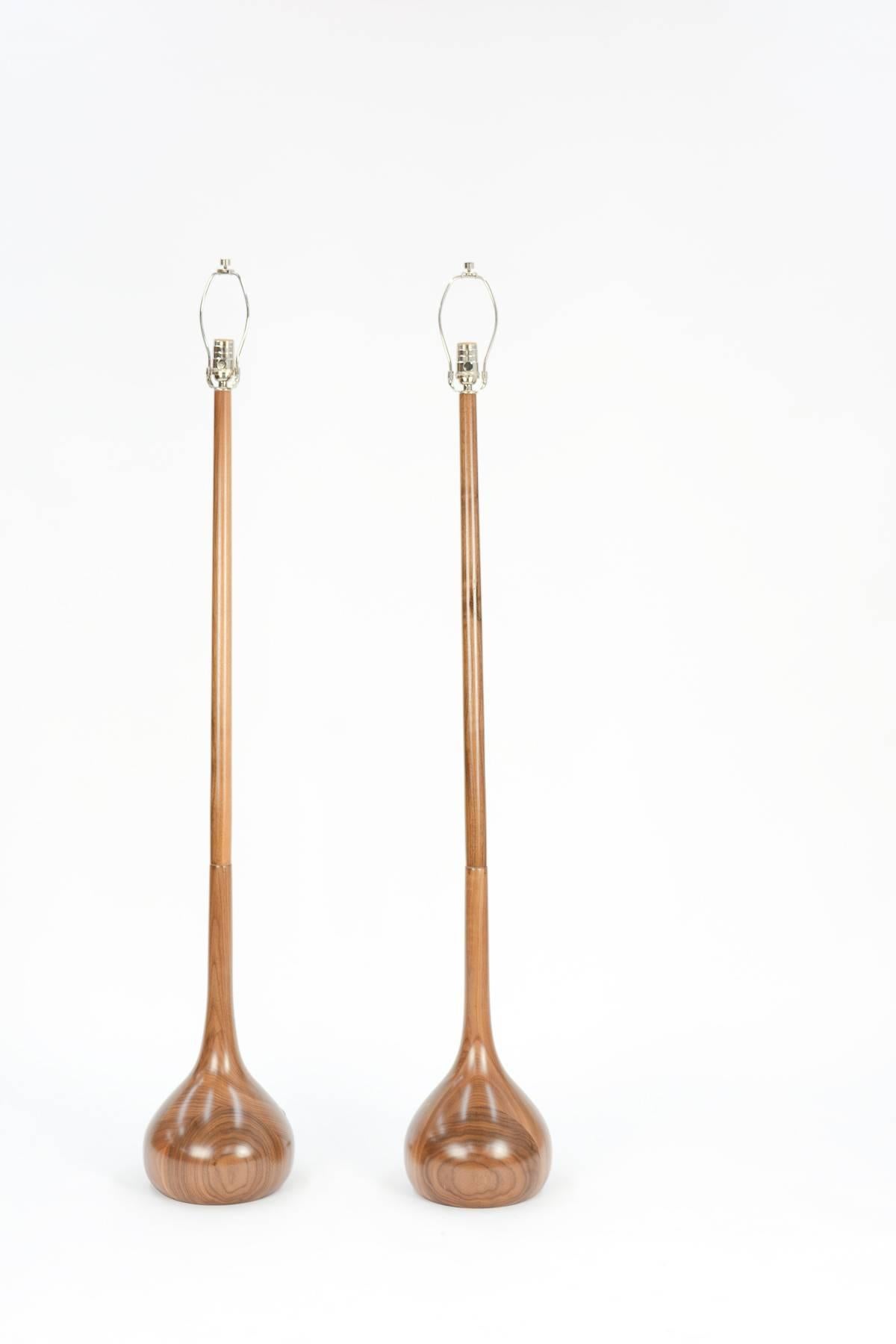 This pair of hand-carved European walnut tulip bulb floor lamps are the latest of 20th century Studio's own design work. The walnut grain patterns in these lamps is extraordinary, with graining unique to each lamp.

Please note: Lamp shades