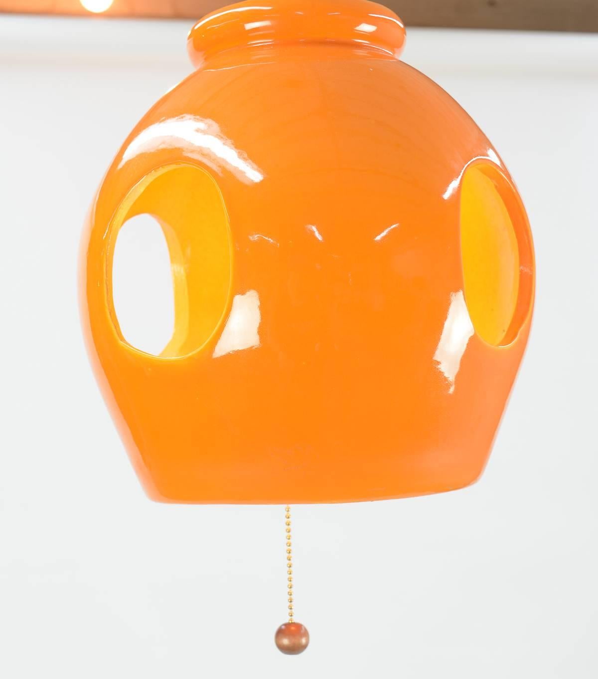 This playful orange ceramic pop art pendant lamp will delightfully light up the room in more ways than one.  A California Mid-Century classic.