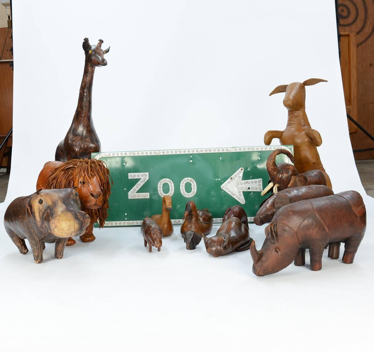 A 14 piece zoo, including Dimitri Omersa's hippo, rhino, pig, giraffe. kangaroo, lion, elephant, small rhino, elephant bank, two ducks, pig, and a ceramic sleeping cat, plus a zoo sign from California.