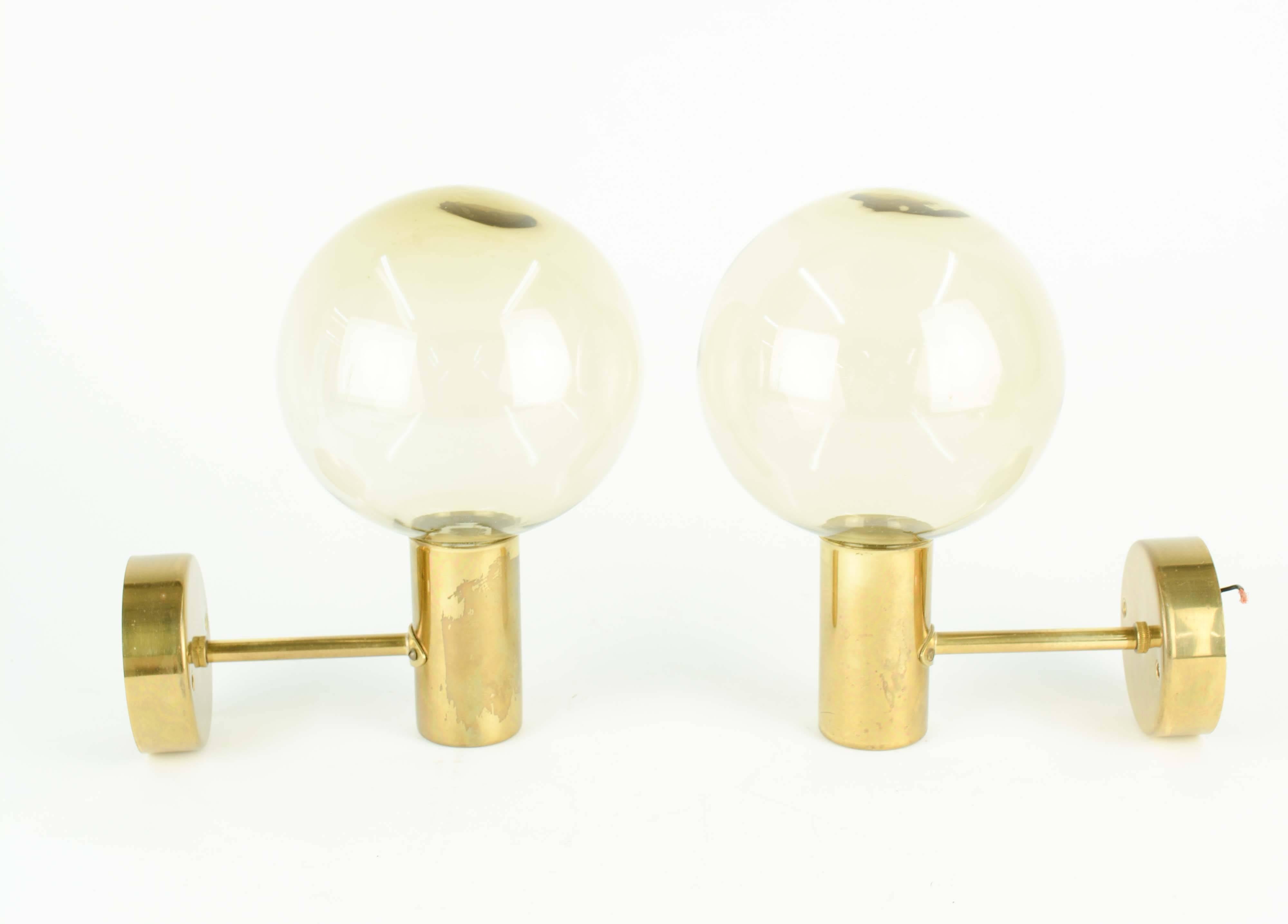 Hans-Agne Jakobsson's Model V-149 wall scones with smoked and handblown glass sconces. Produced in Sweden in the 1960s and feature brass fixtures and smoked glass globes.