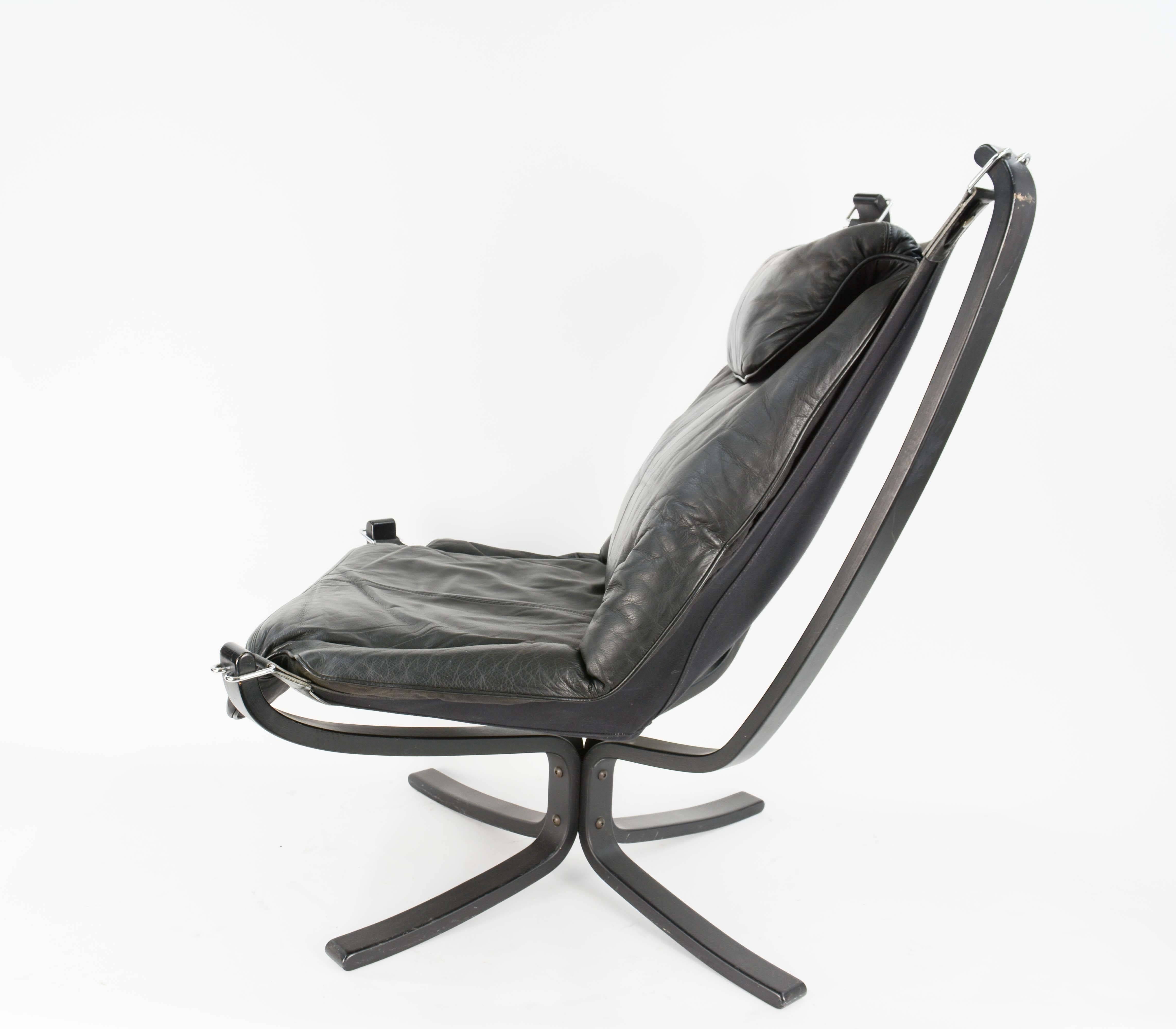 Iconic Falcon chairs designed by Sigurd Resell (1920-2010) by Vatne Møbler, Norway.
Black bended wooden frame, stretched with canvas, great patinated black leather cushions and slings. The slings are attached with chrome hardware. 

We have up to