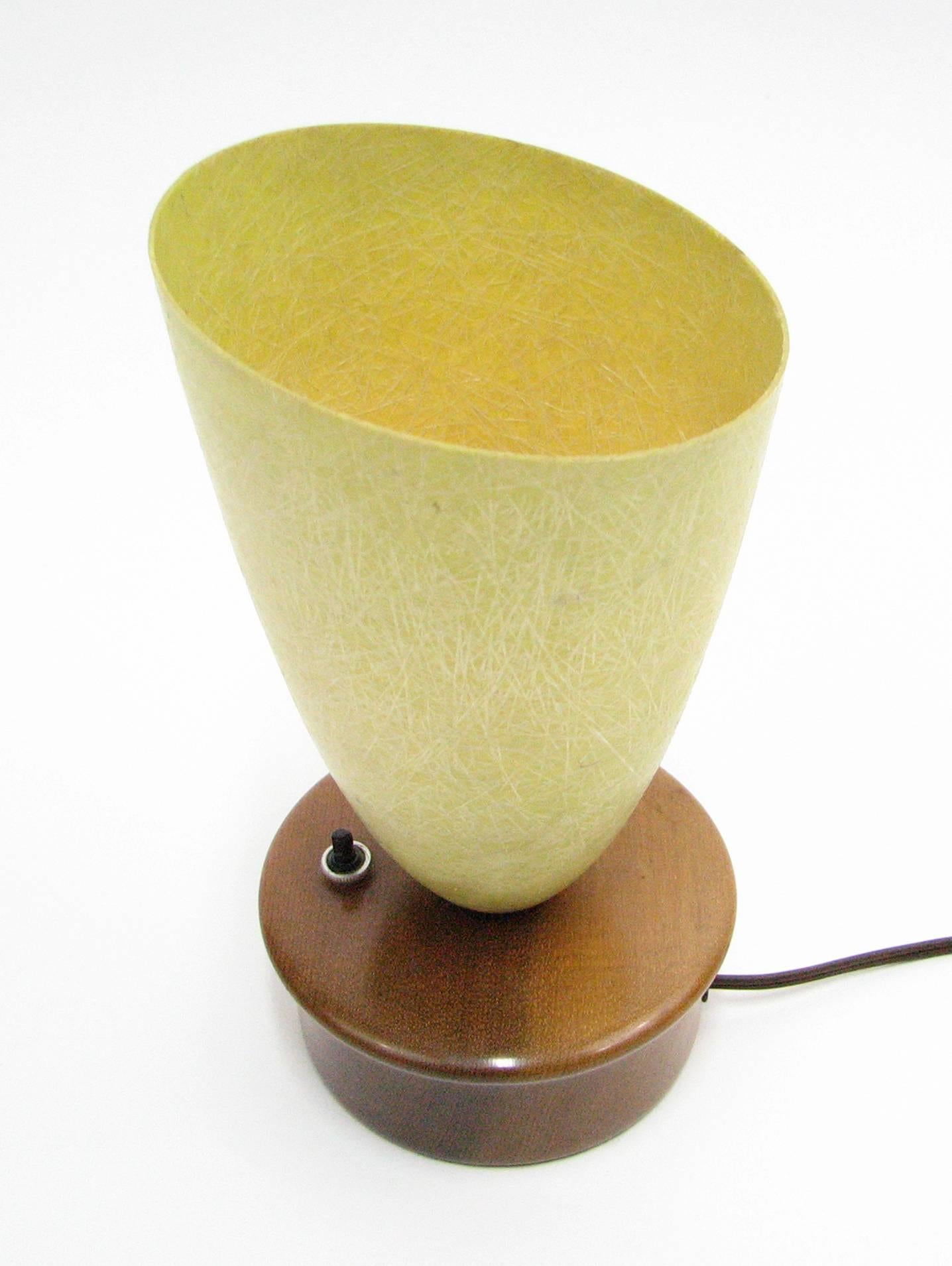 This Mid-Century uplight table lamp with its subdued ochre fiberglass shade and handcrafted base in old-growth Oregon myrtlewood is a work of artful simplicity. 

Push-button on/off switch on the base.

Label on the underside of the base reads,