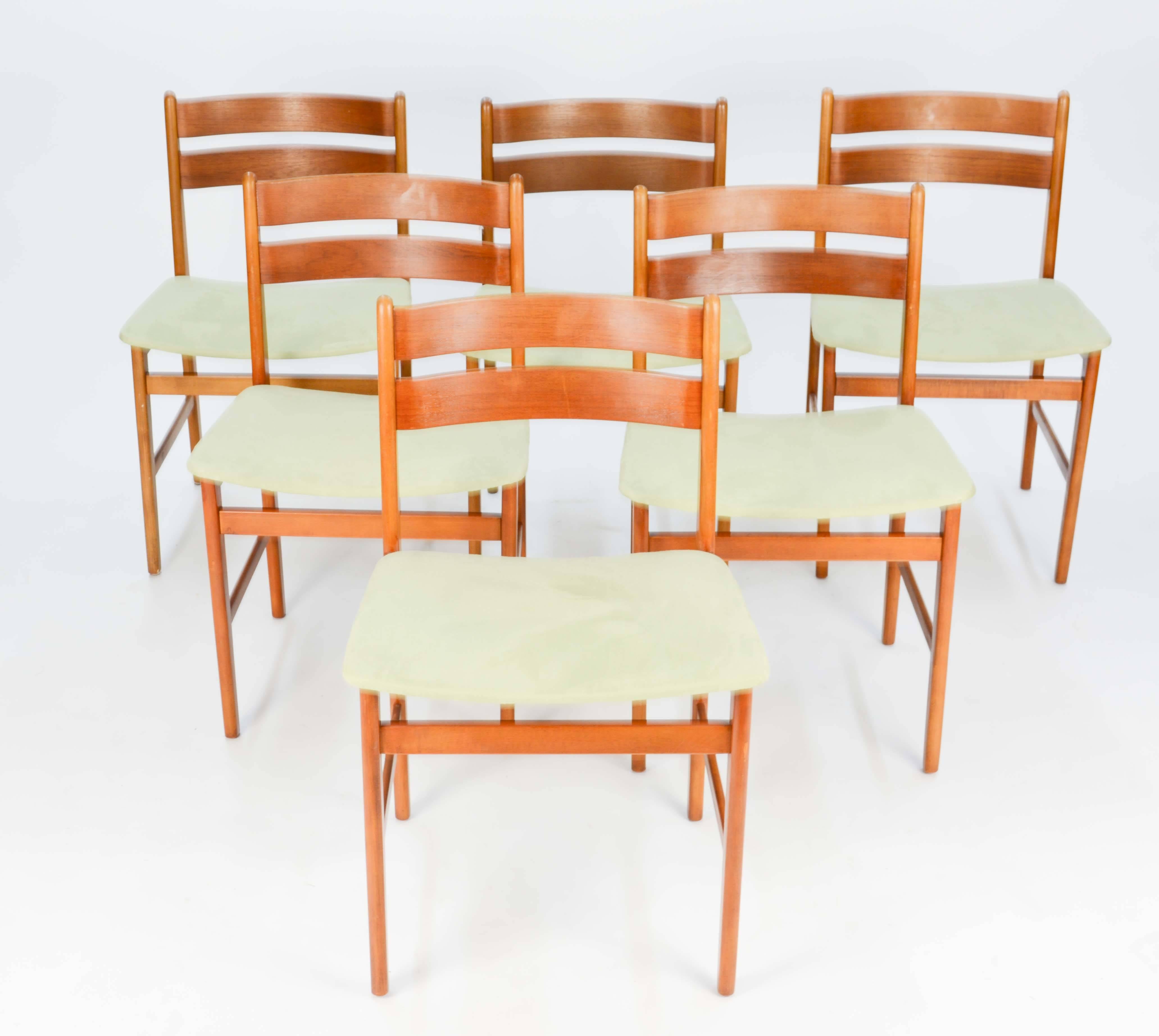 A handsome set of six Danish curved back dining chairs with new green suede seats.